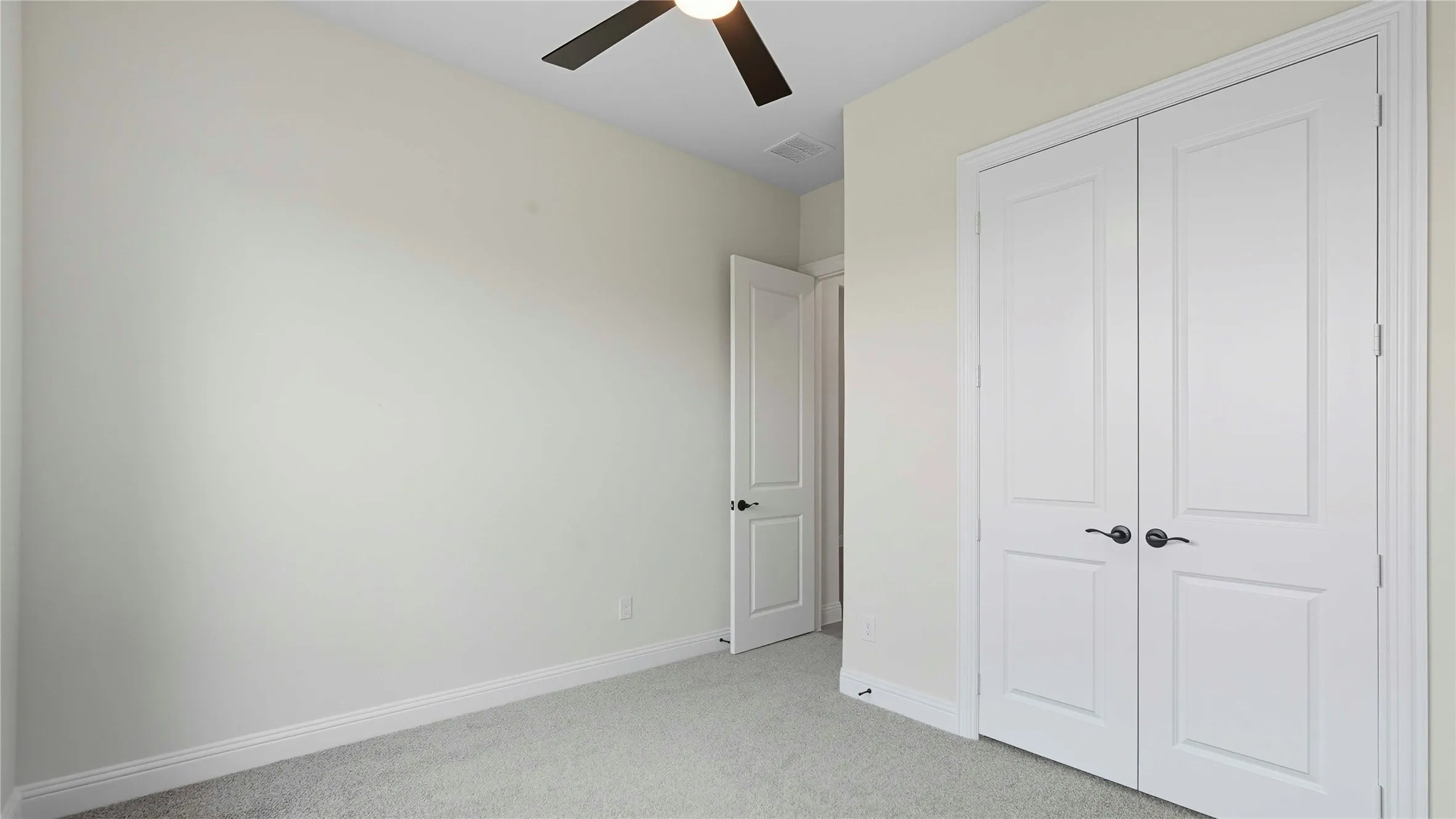 Interior room featuring light-colored walls and carpeted flooring