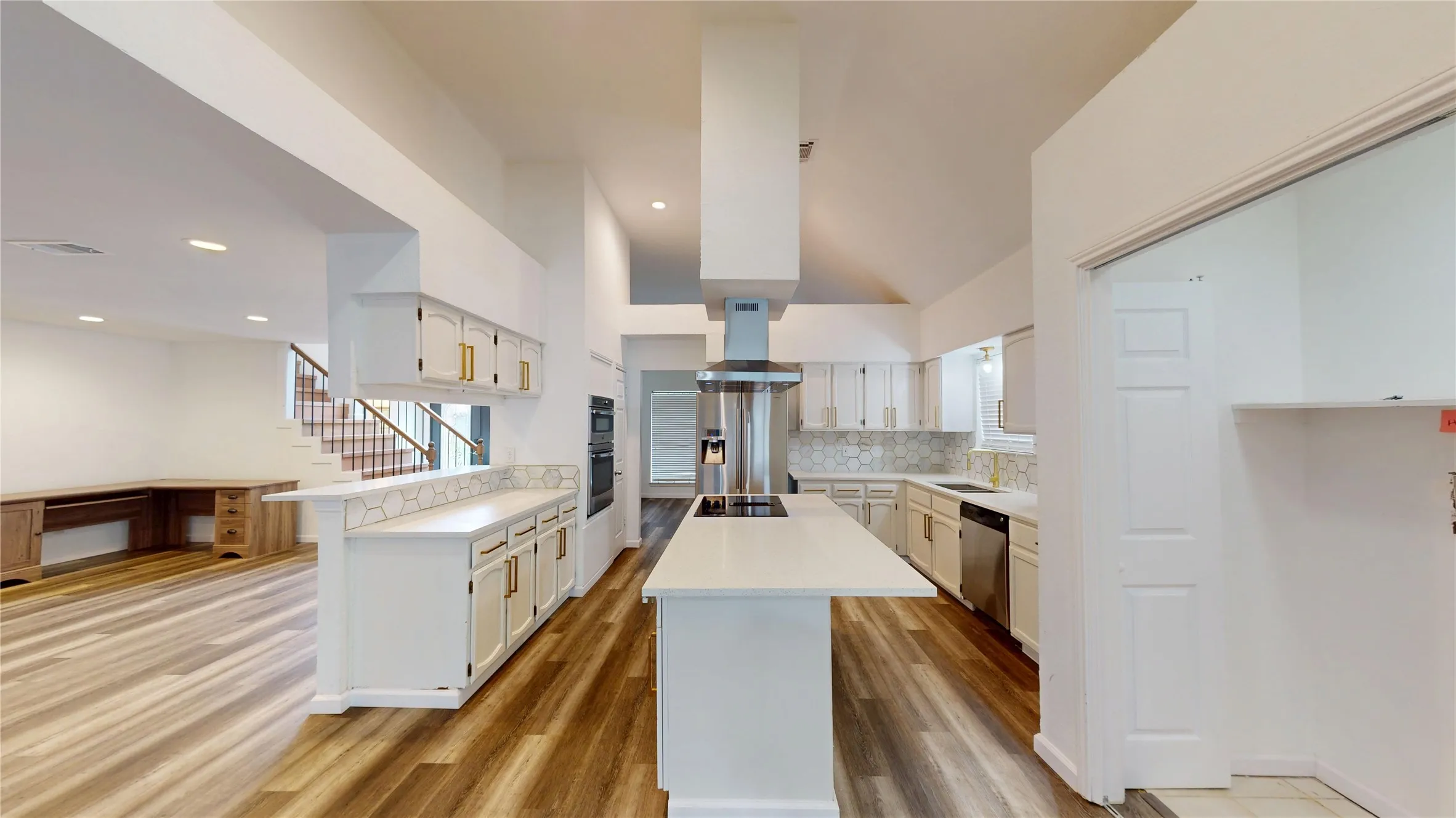 Kitchen with light wood-style flooring, a kitchen island, stainless steel appliances, white cabinets, and extractor fan