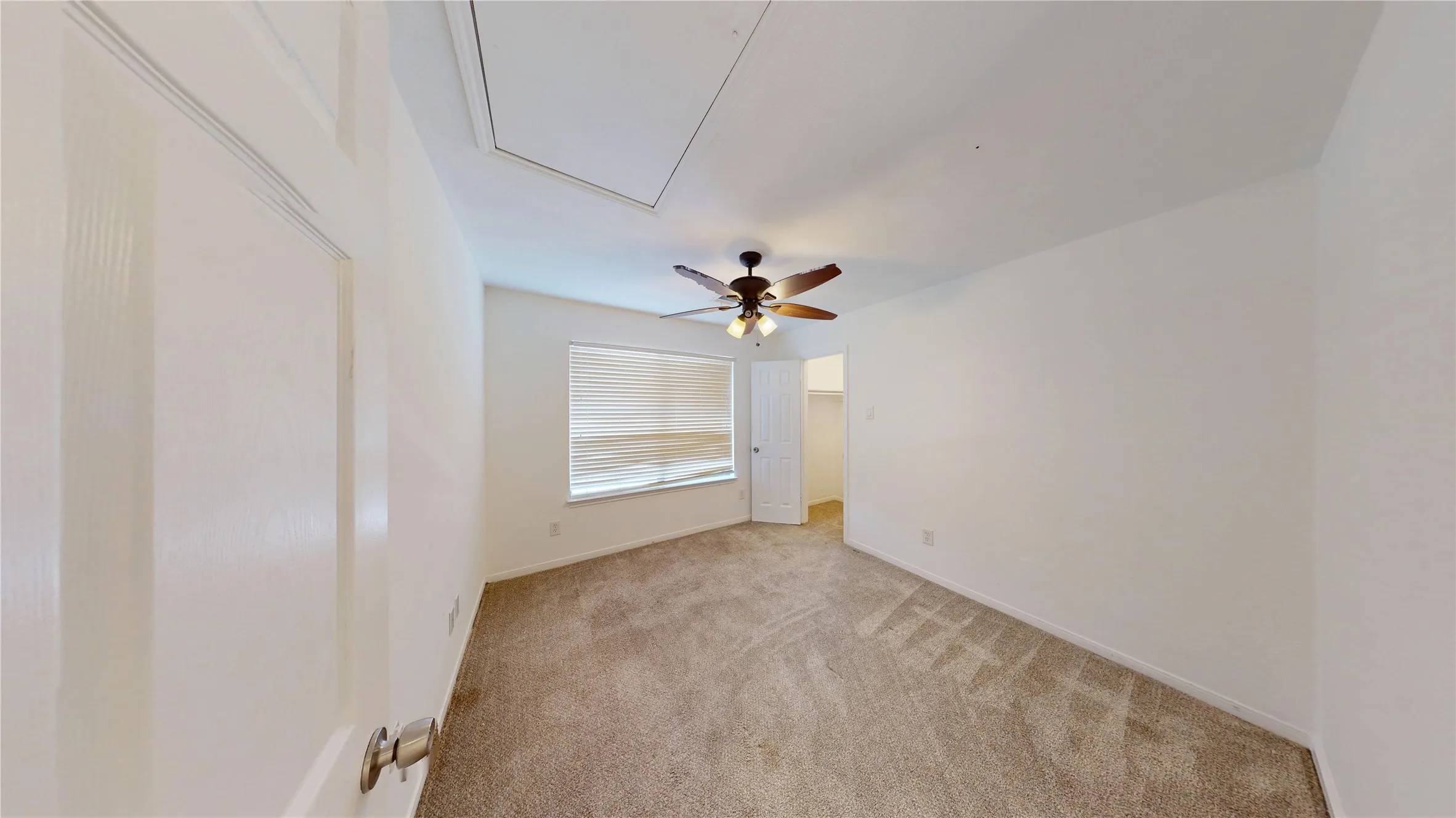Empty room with light carpet and a ceiling fan