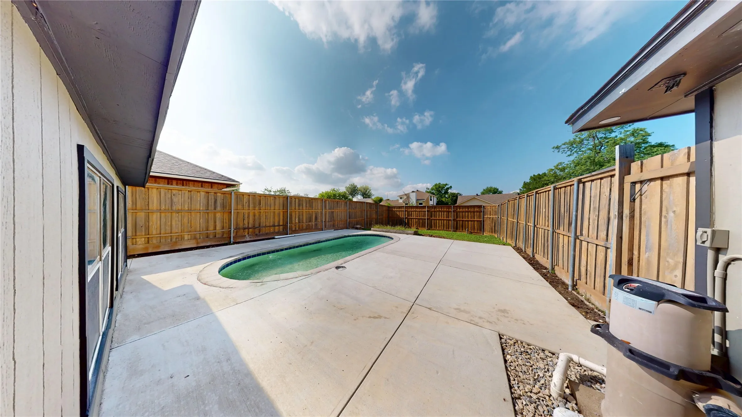 View of pool featuring patio surround and a fenced backyard