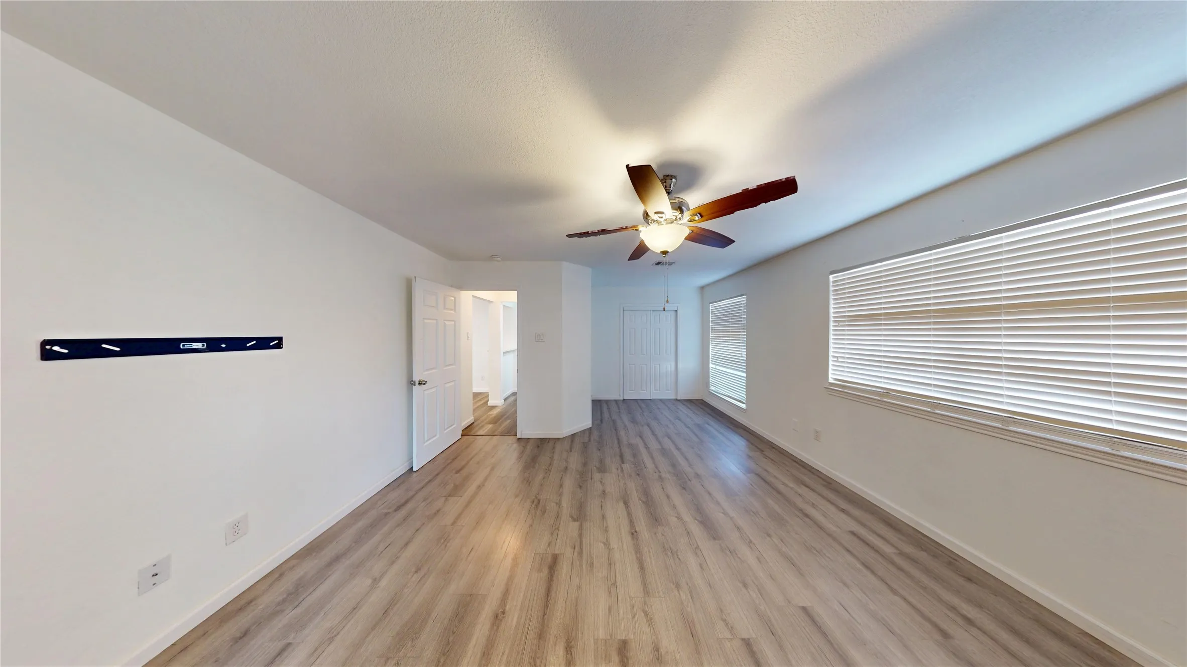 Unfurnished bedroom with light wood-style flooring, ceiling fan, and a closet