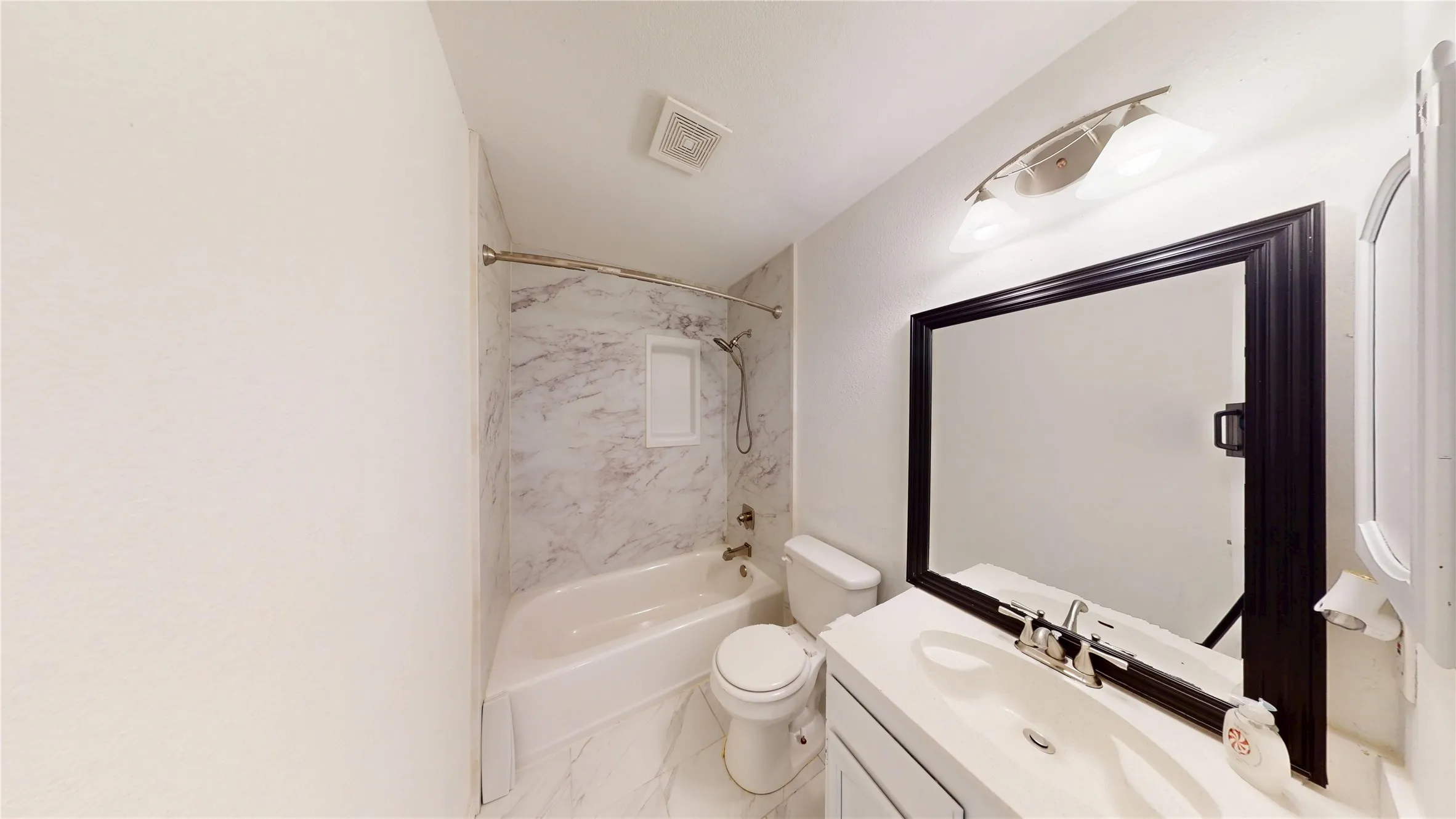 Full bath with vanity, washtub / shower combination, and light marble finish flooring
