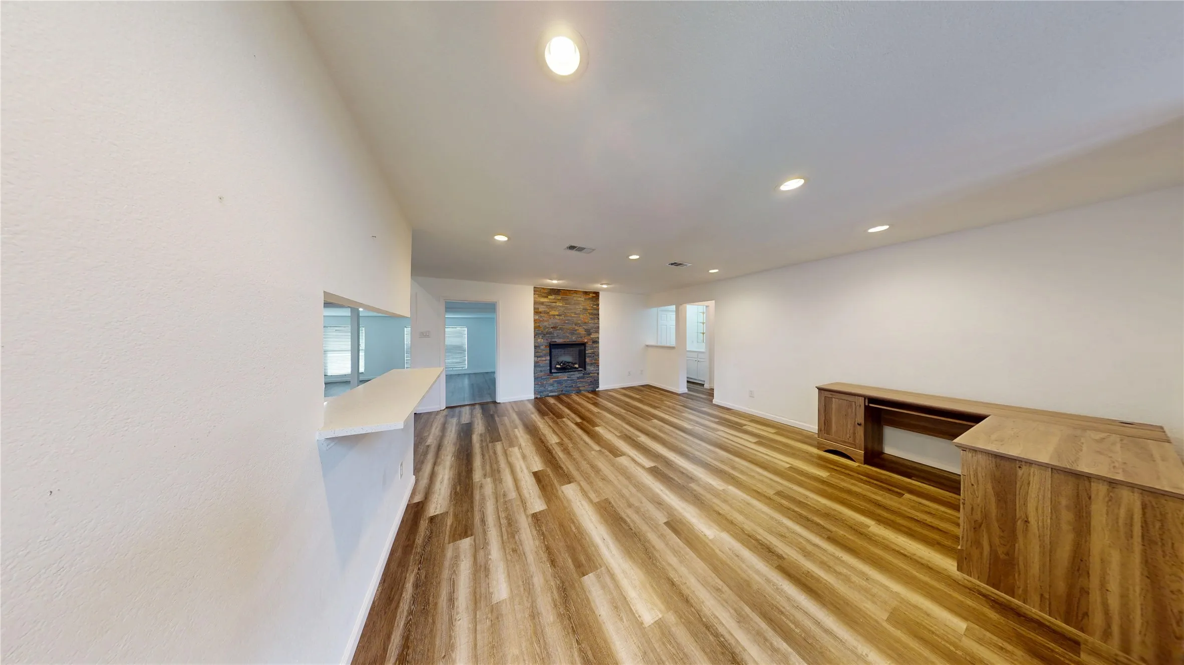 Unfurnished living room with recessed lighting, light wood-type flooring, and a stone fireplace