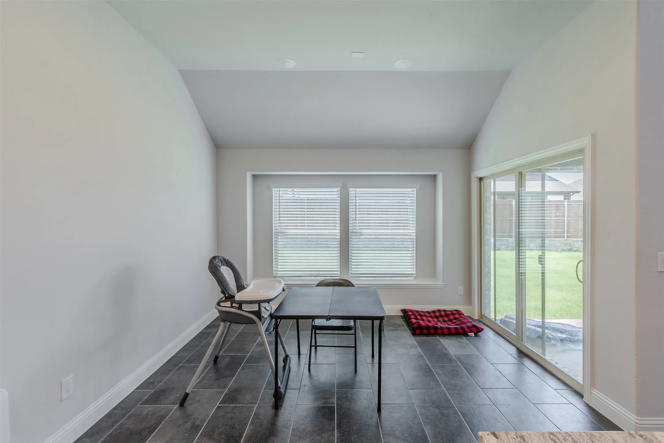 Dining space with baseboards and lofted ceiling