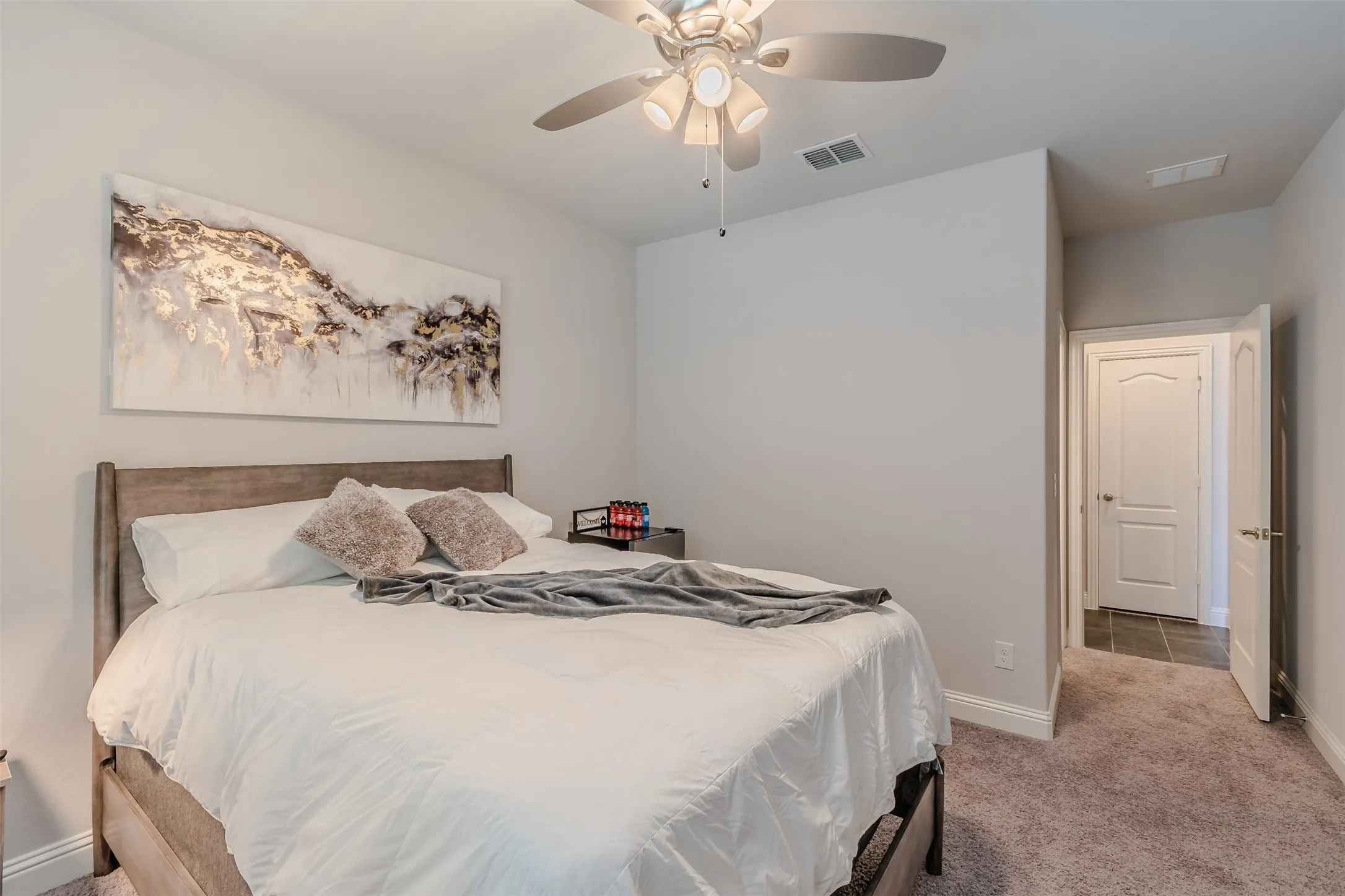 Bedroom with light carpet and a ceiling fan