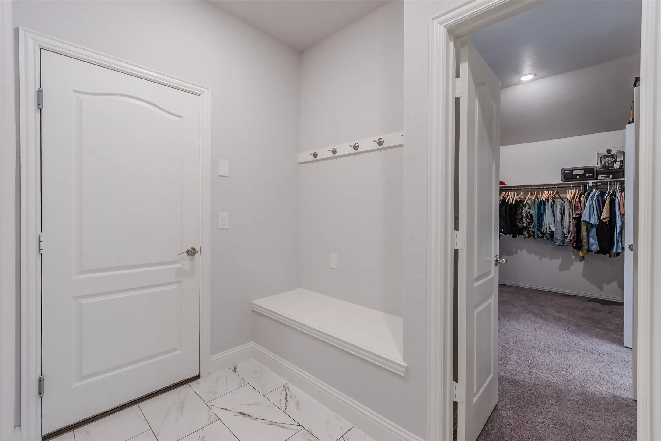 Mudroom featuring baseboards and light marble finish flooring