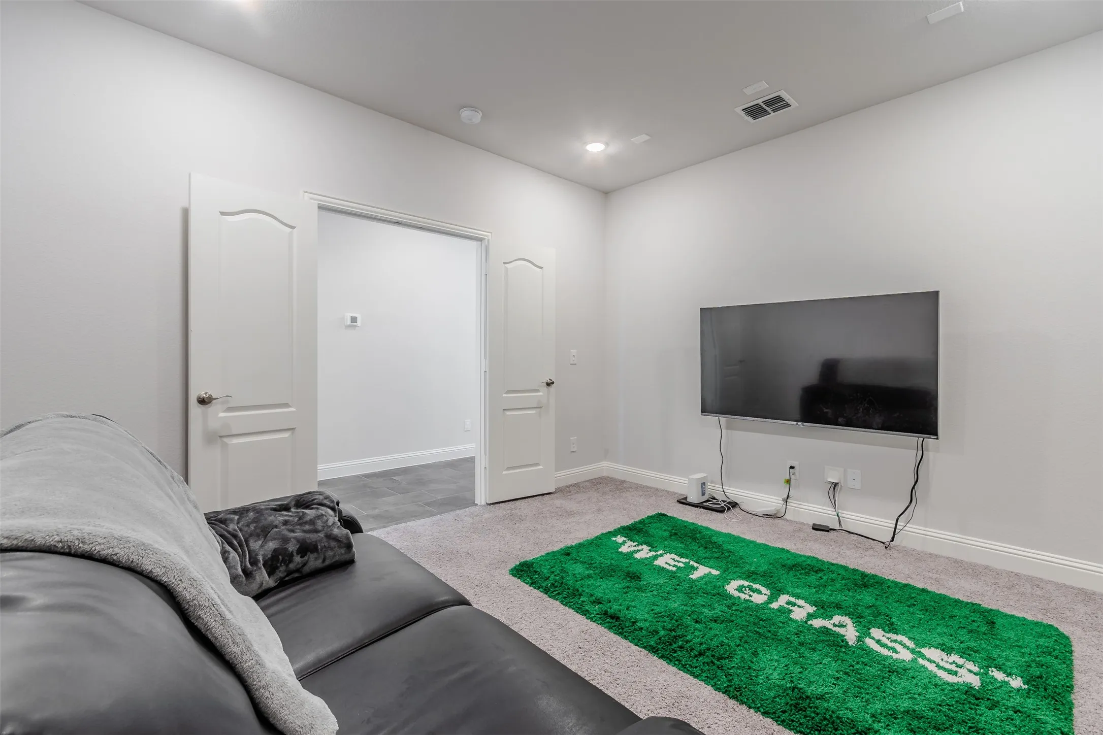 Living room with light colored carpet and recessed lighting