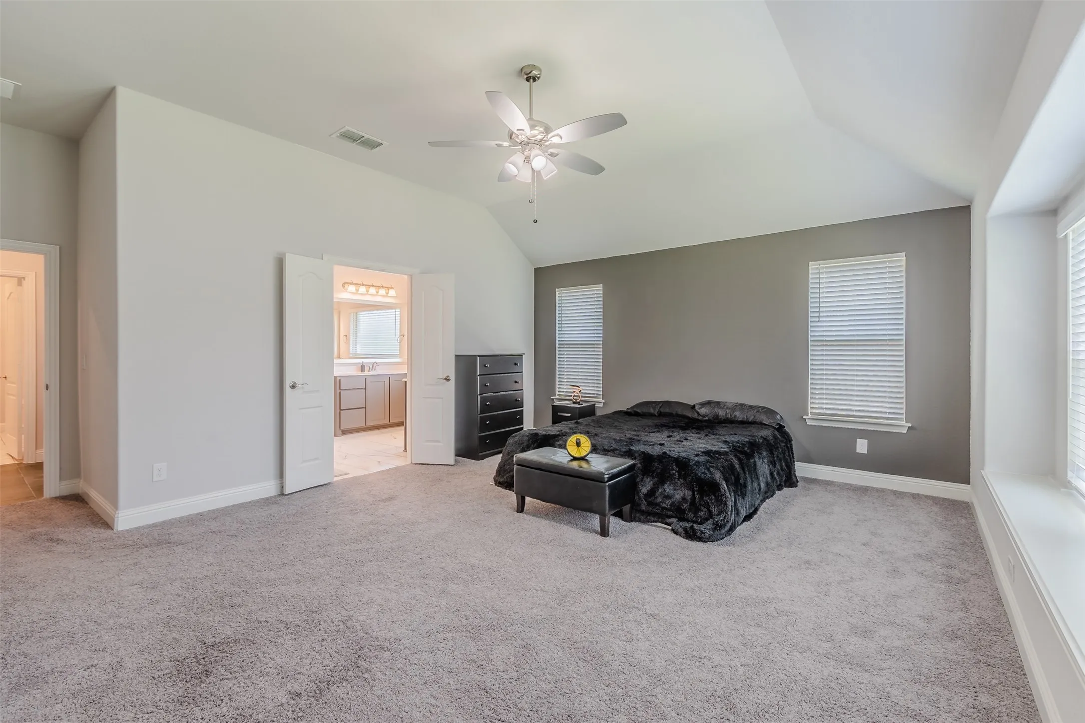 Bedroom with light colored carpet, a ceiling fan, and lofted ceiling