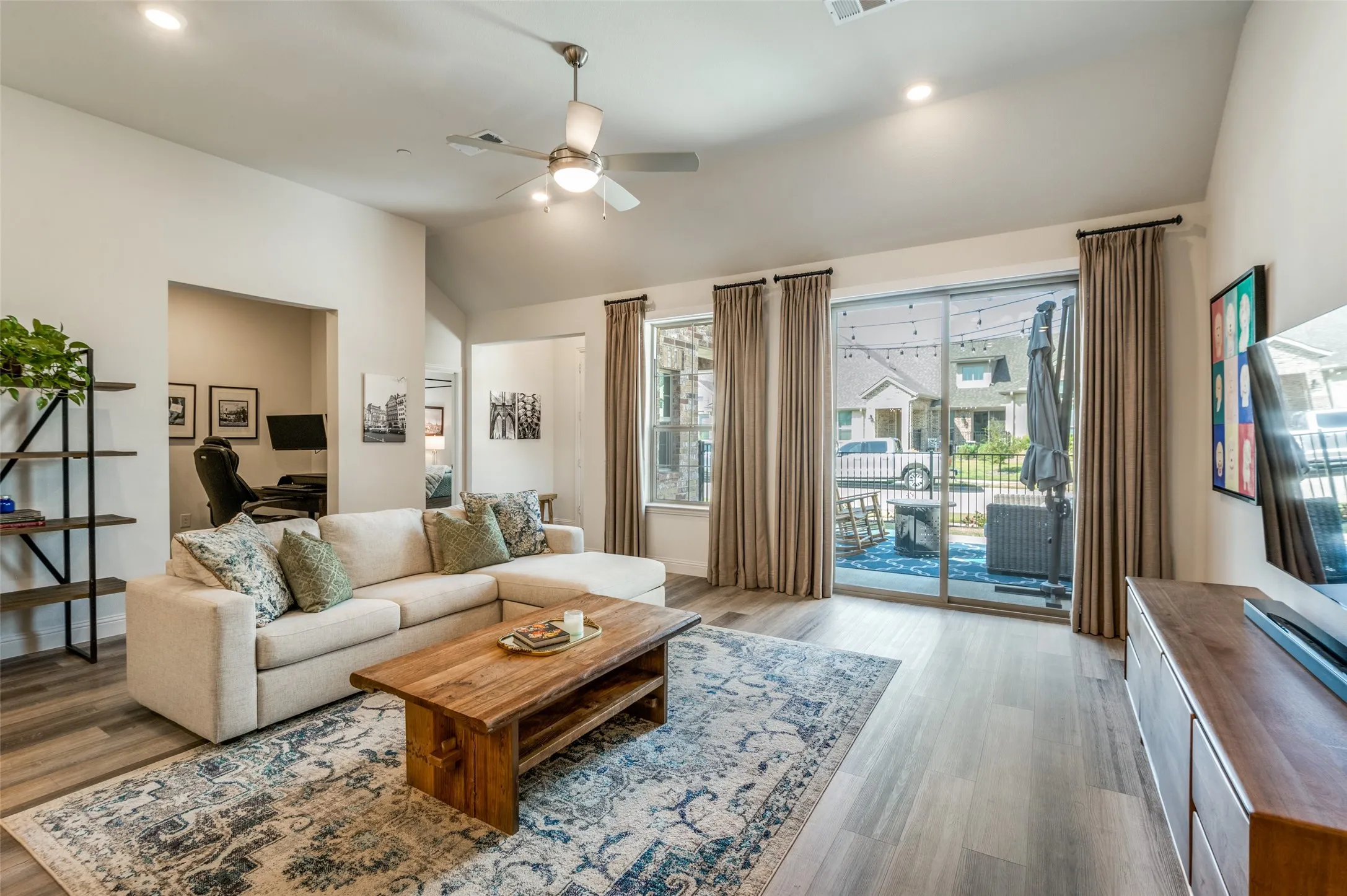 Bright and inviting living area with high ceilings, abundant natural light, and sliding glass doors that open to the patio. The open layout creates a seamless flow for everyday living and entertaining.