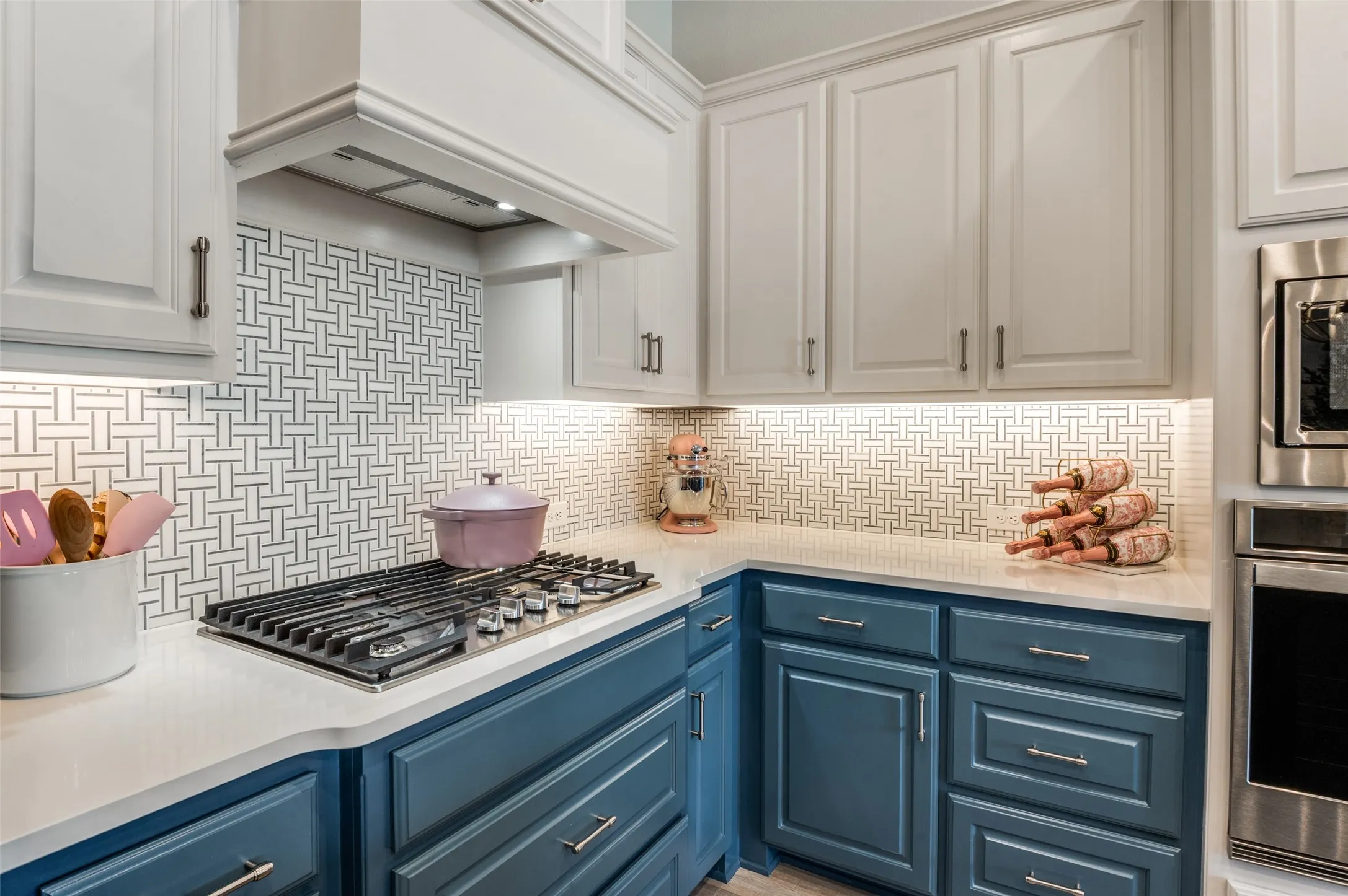 Elegant kitchen finishes including a gas cooktop,  tile backsplash, modern cabinetry, and built-in stainless appliances.