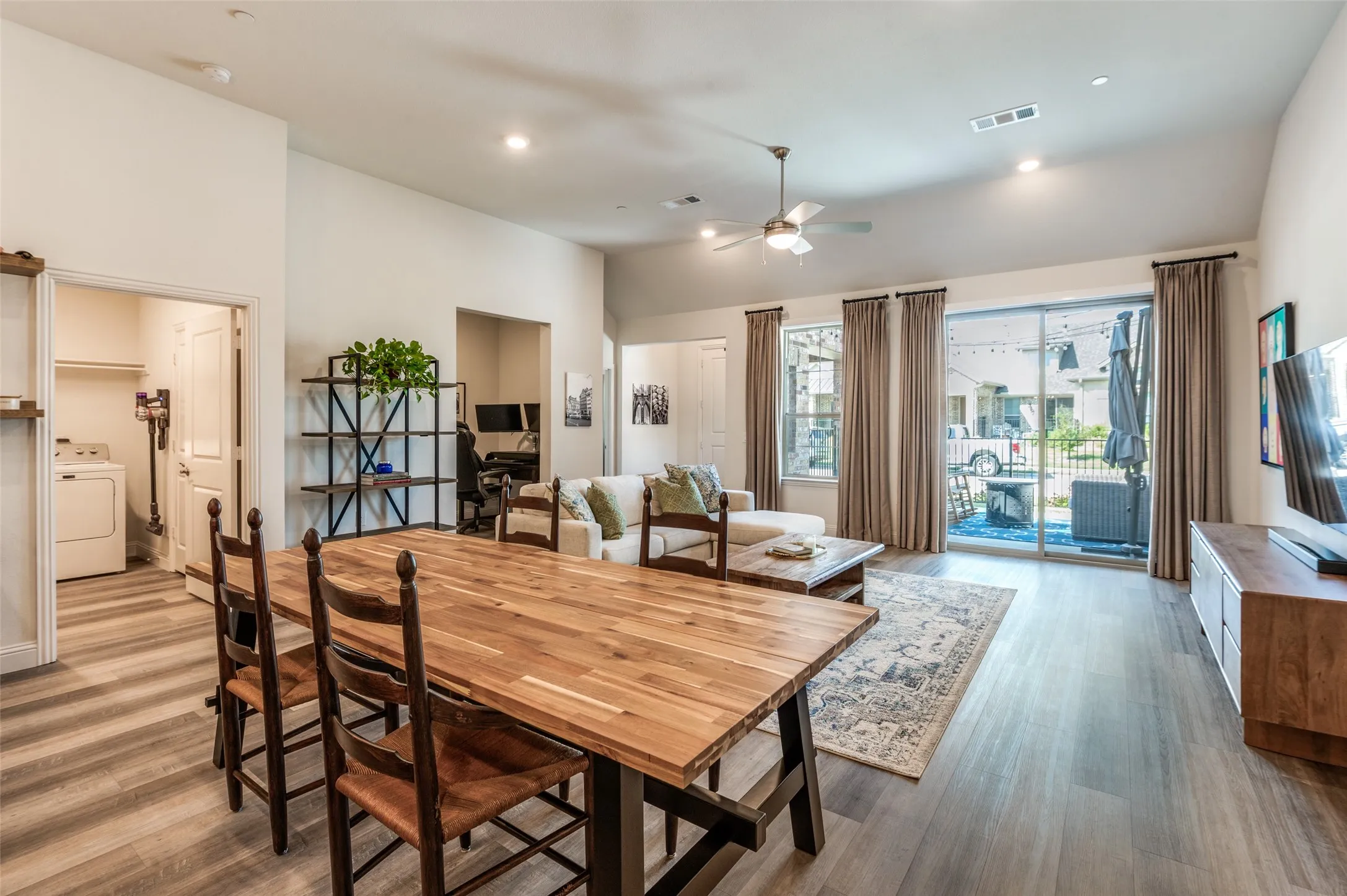 Open dining area seamlessly connected to the kitchen, creating an ideal space for everyday meals and entertaining. Stylish lighting and high ceilings enhance the bright, airy feel.