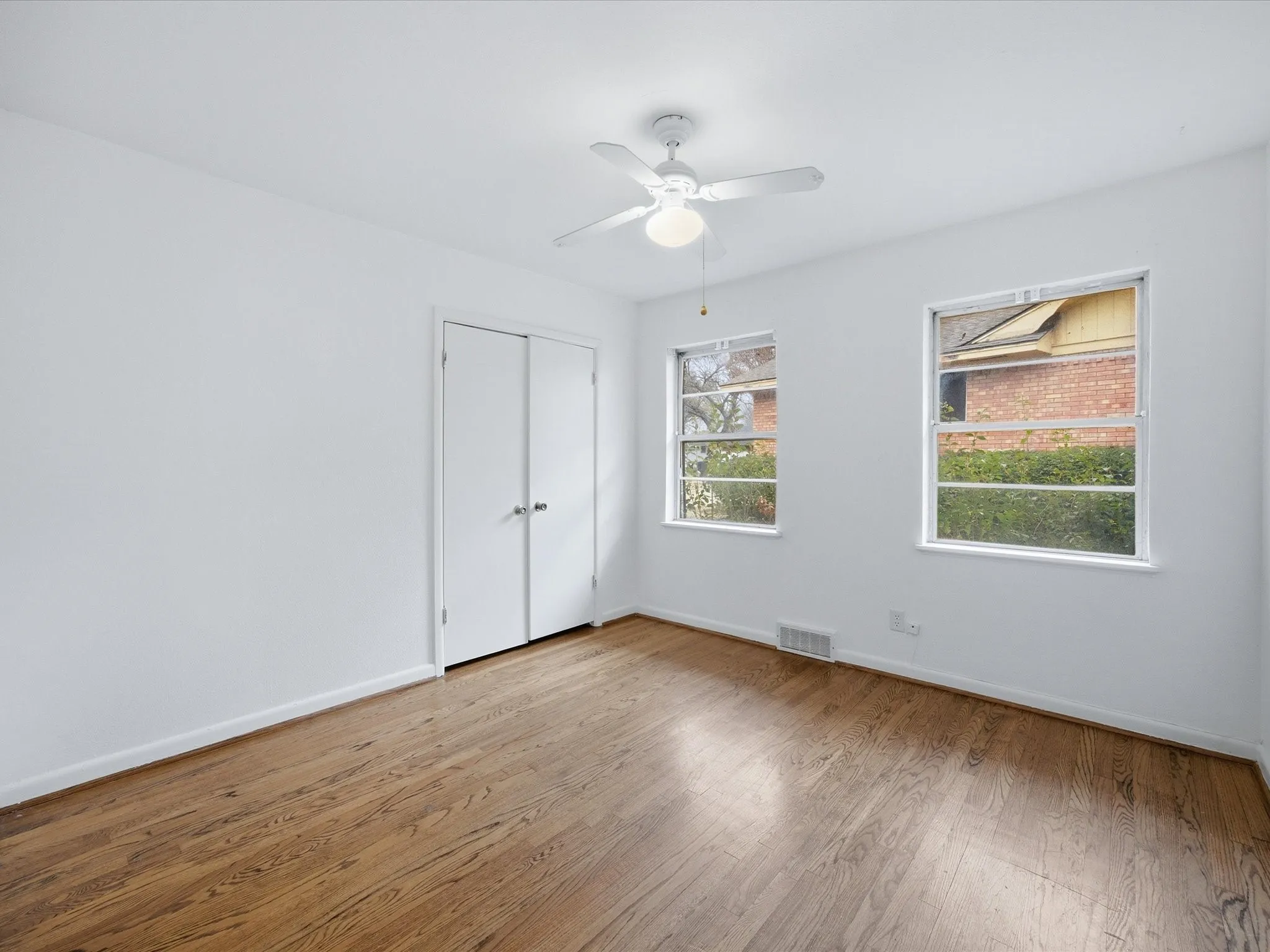 Unfurnished bedroom with wood finished floors, a ceiling fan, and a closet