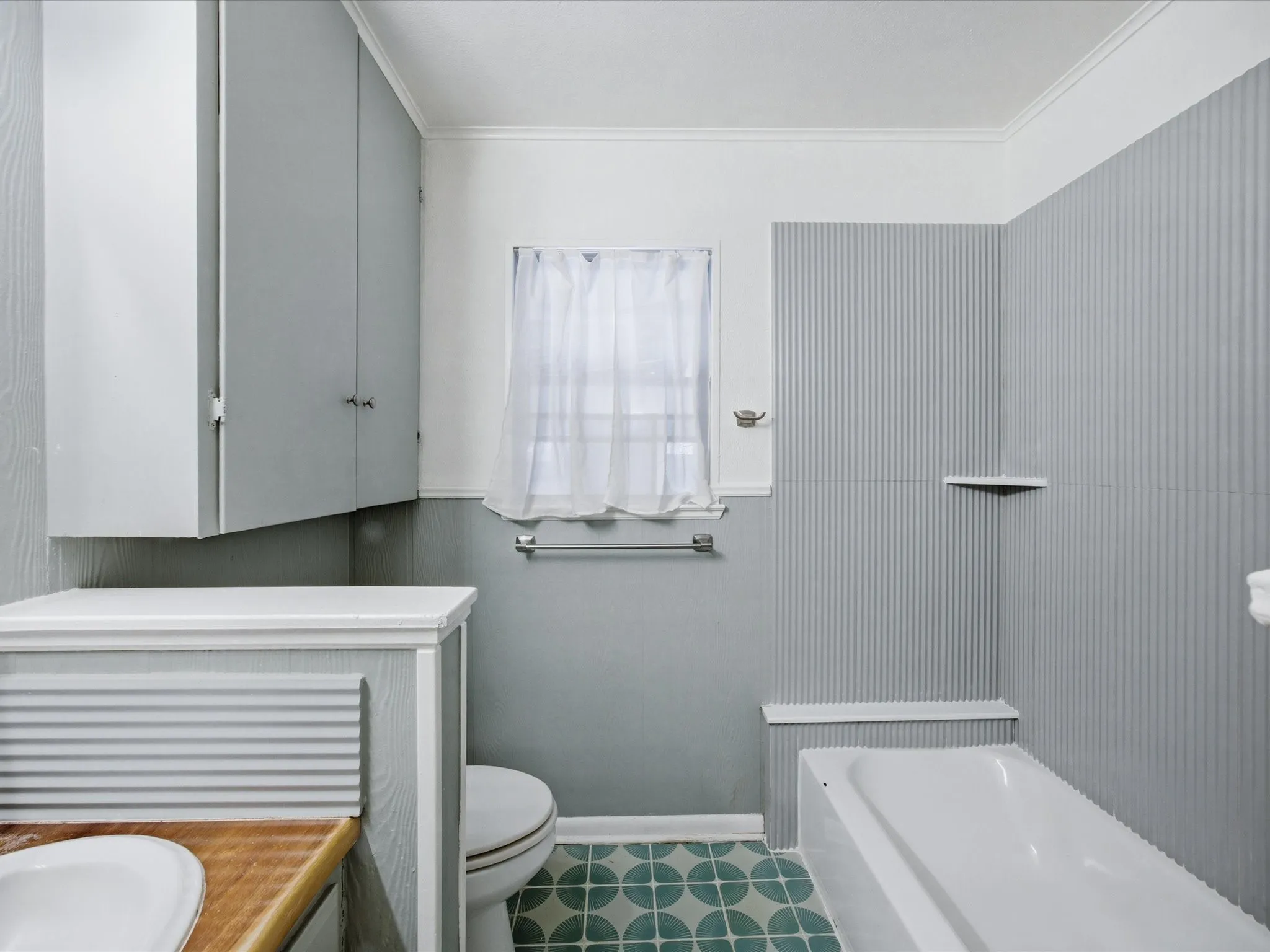 Bathroom with vanity, a garden tub, and crown molding