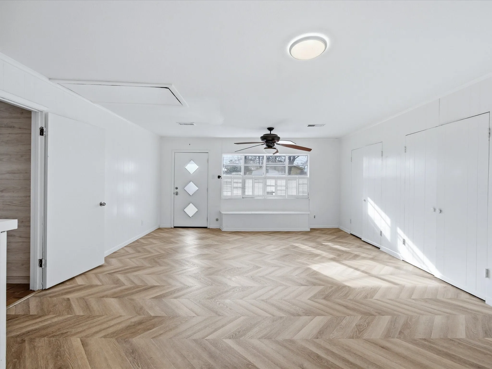 Unfurnished living room featuring parquet flooring and a ceiling fan