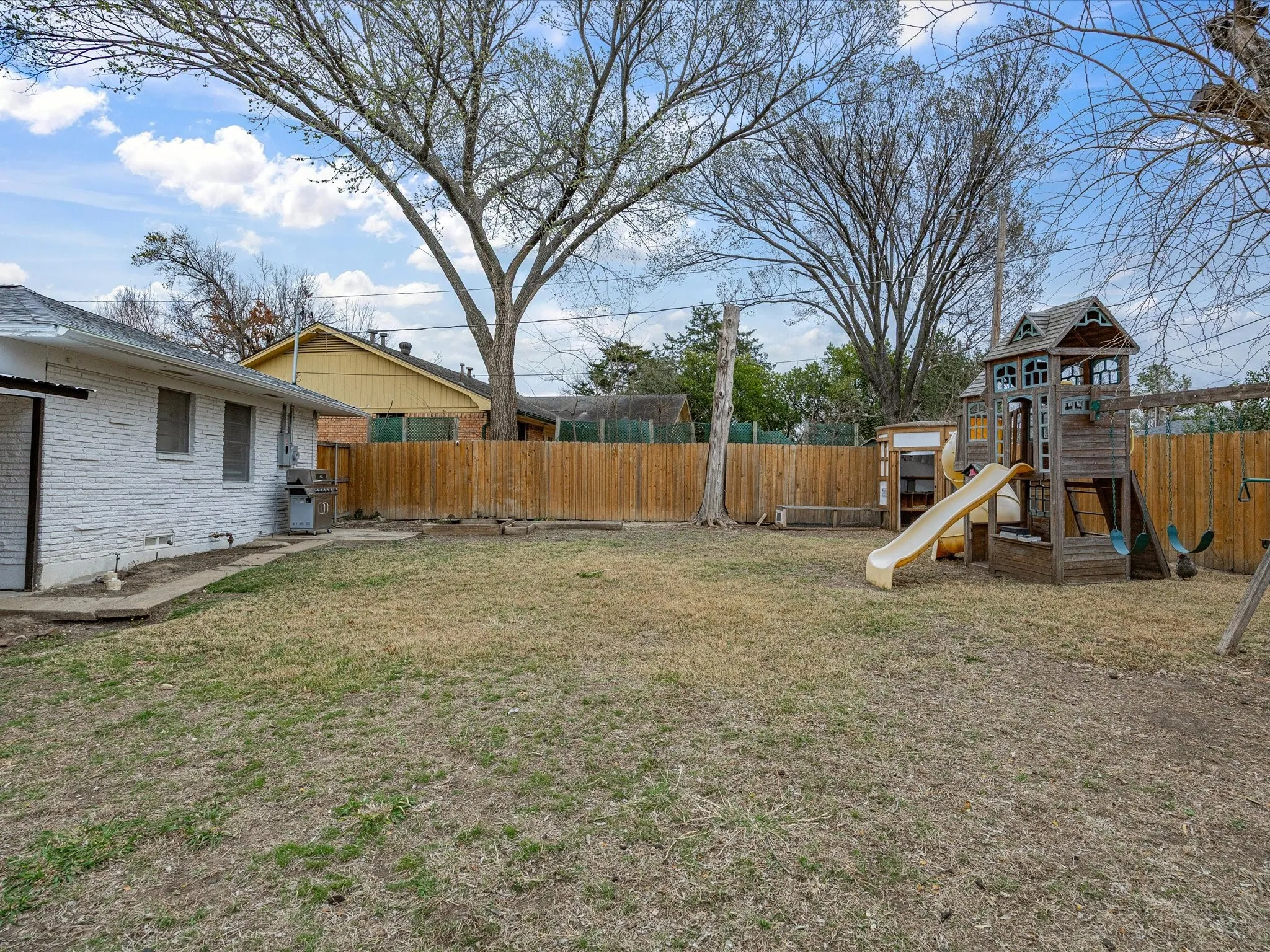 Fenced backyard with a playground