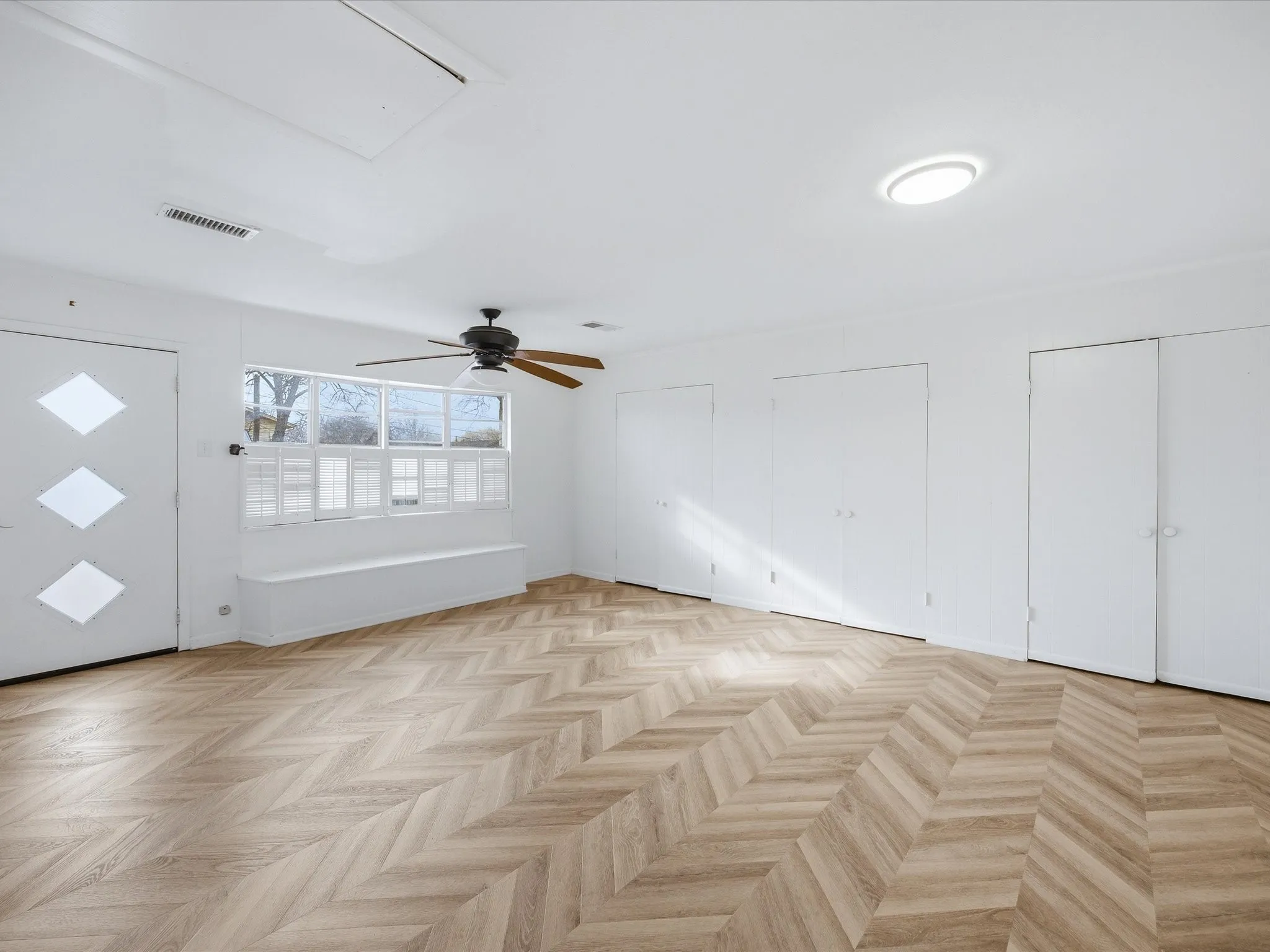 Unfurnished living room featuring parquet flooring and a ceiling fan