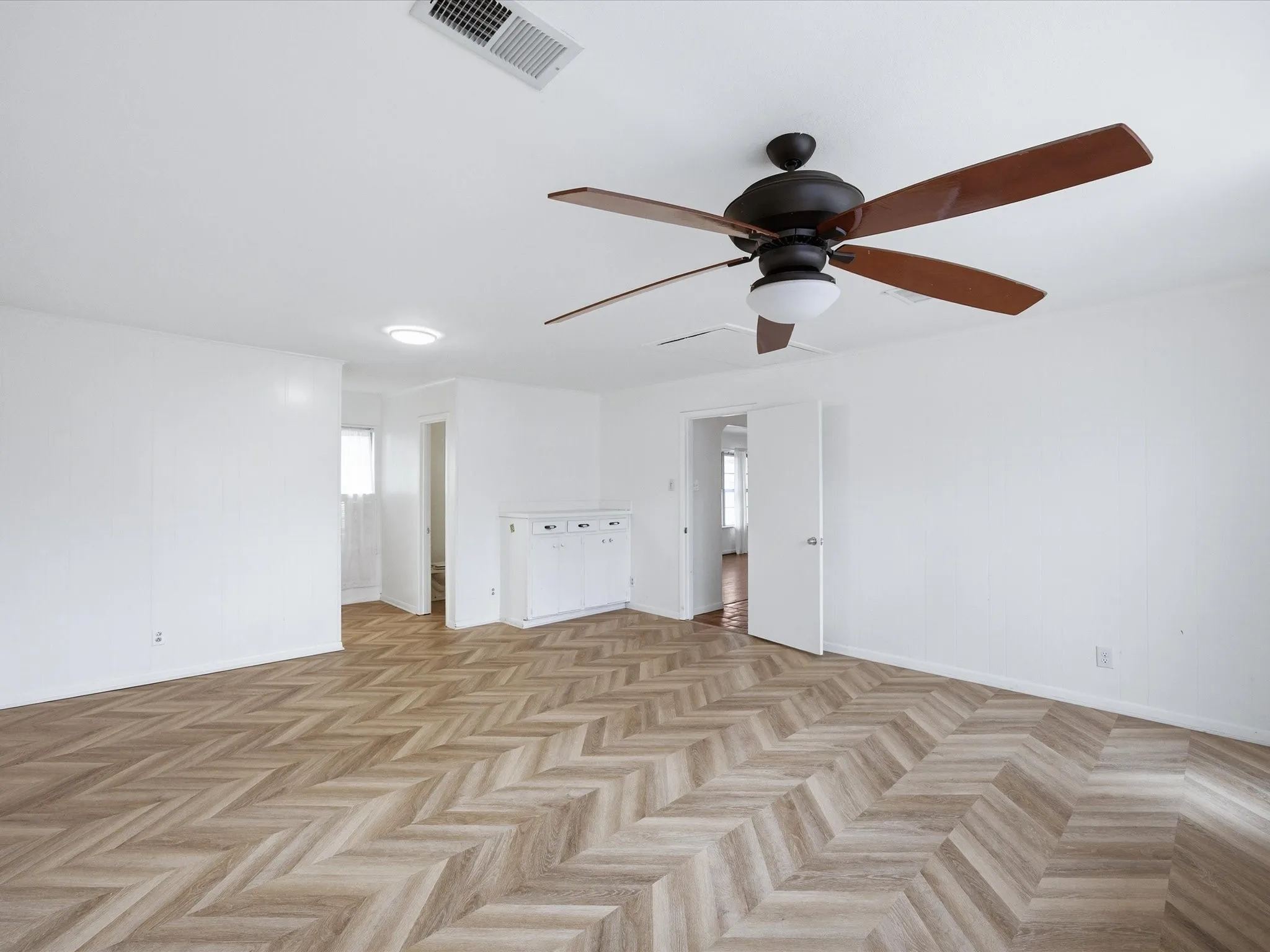 Unfurnished living room featuring parquet flooring and a ceiling fan