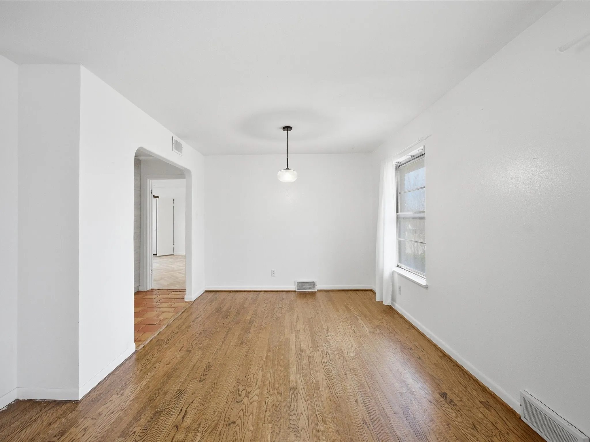 Unfurnished dining area with light wood-style floors and arched walkways
