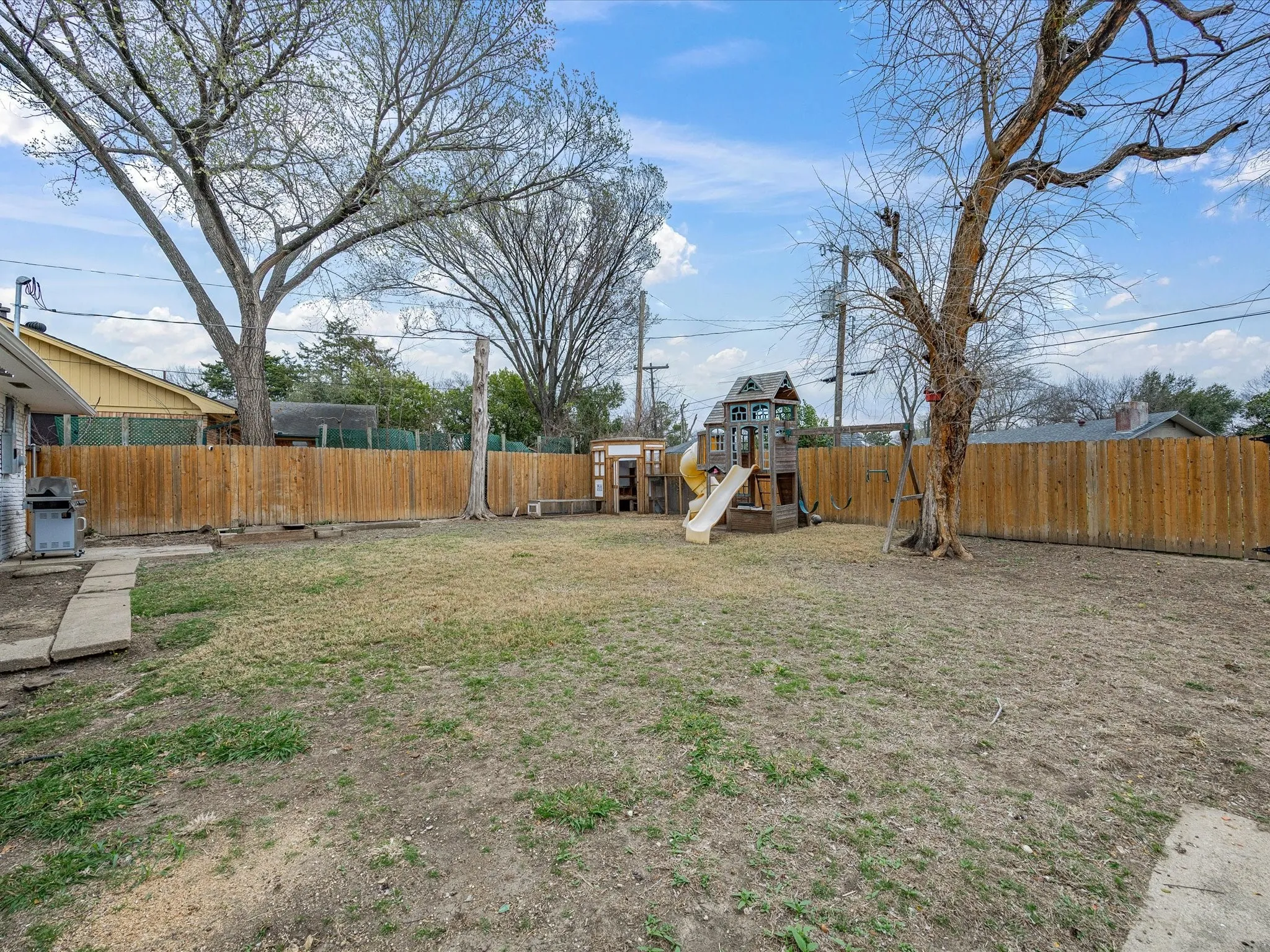 Fenced backyard with a playground