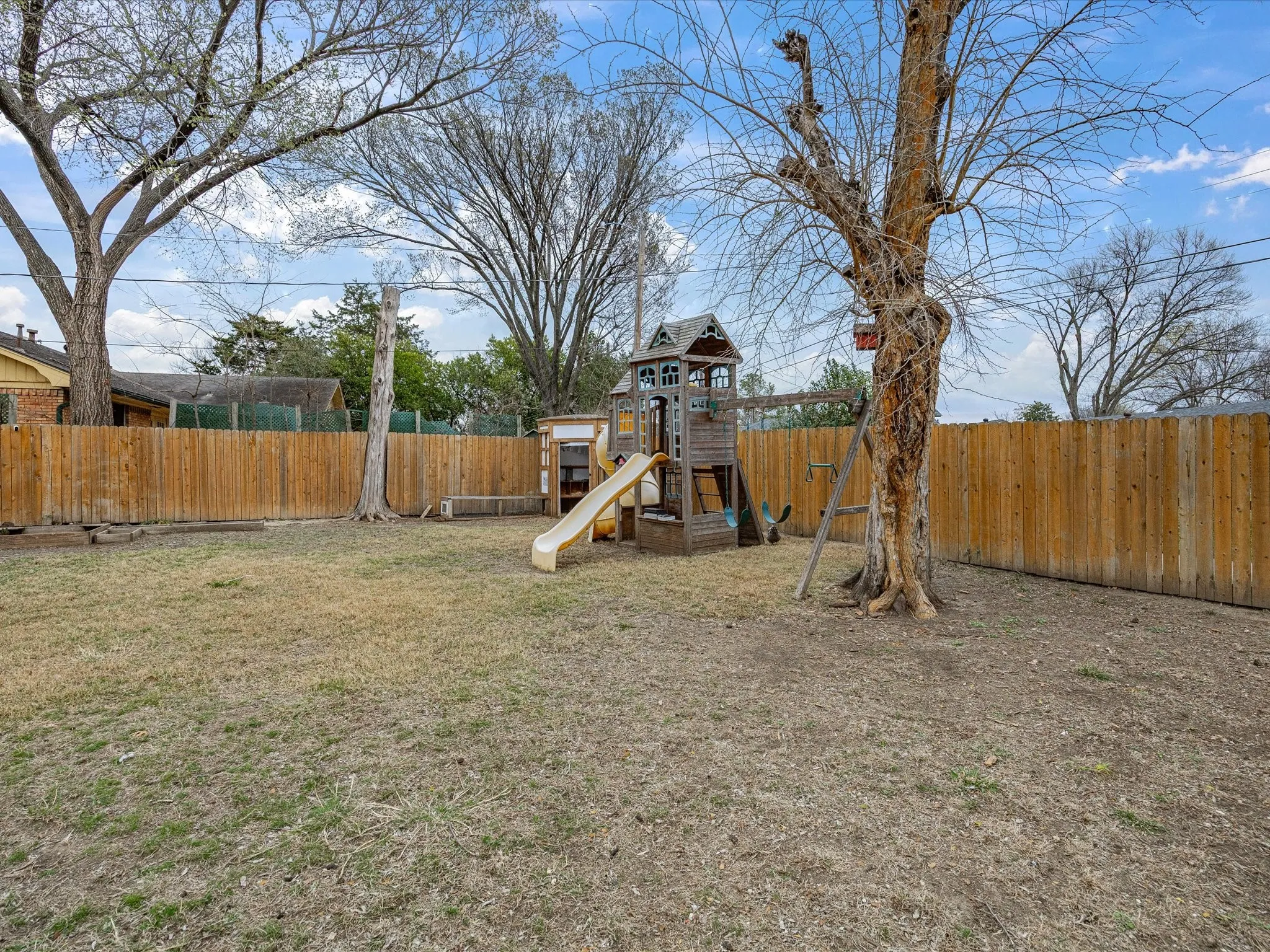 View of play area with a fenced backyard