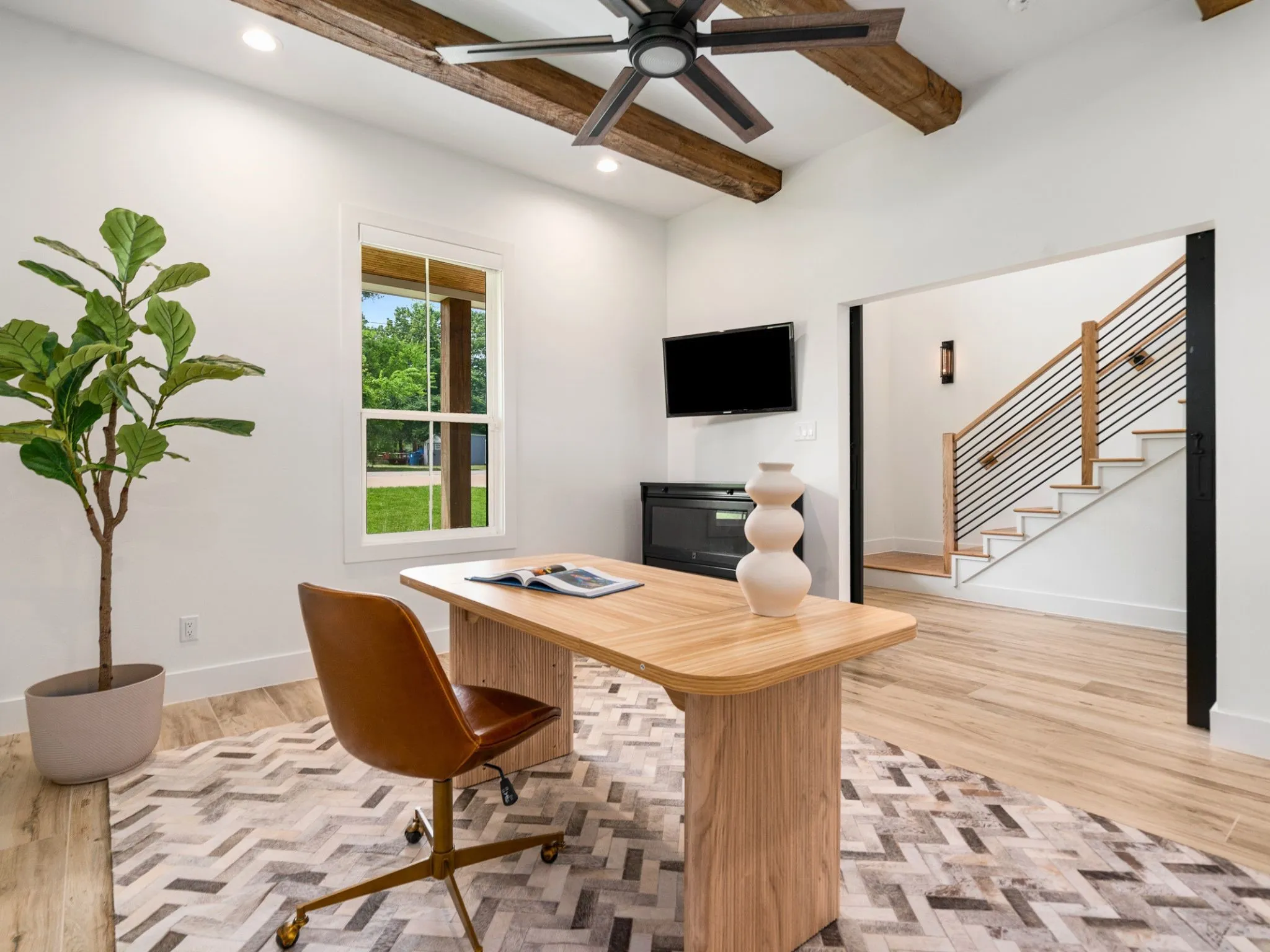 Room featuring vaulted ceilings with exposed wood beams, a modern ceiling fan, and recessed lighting