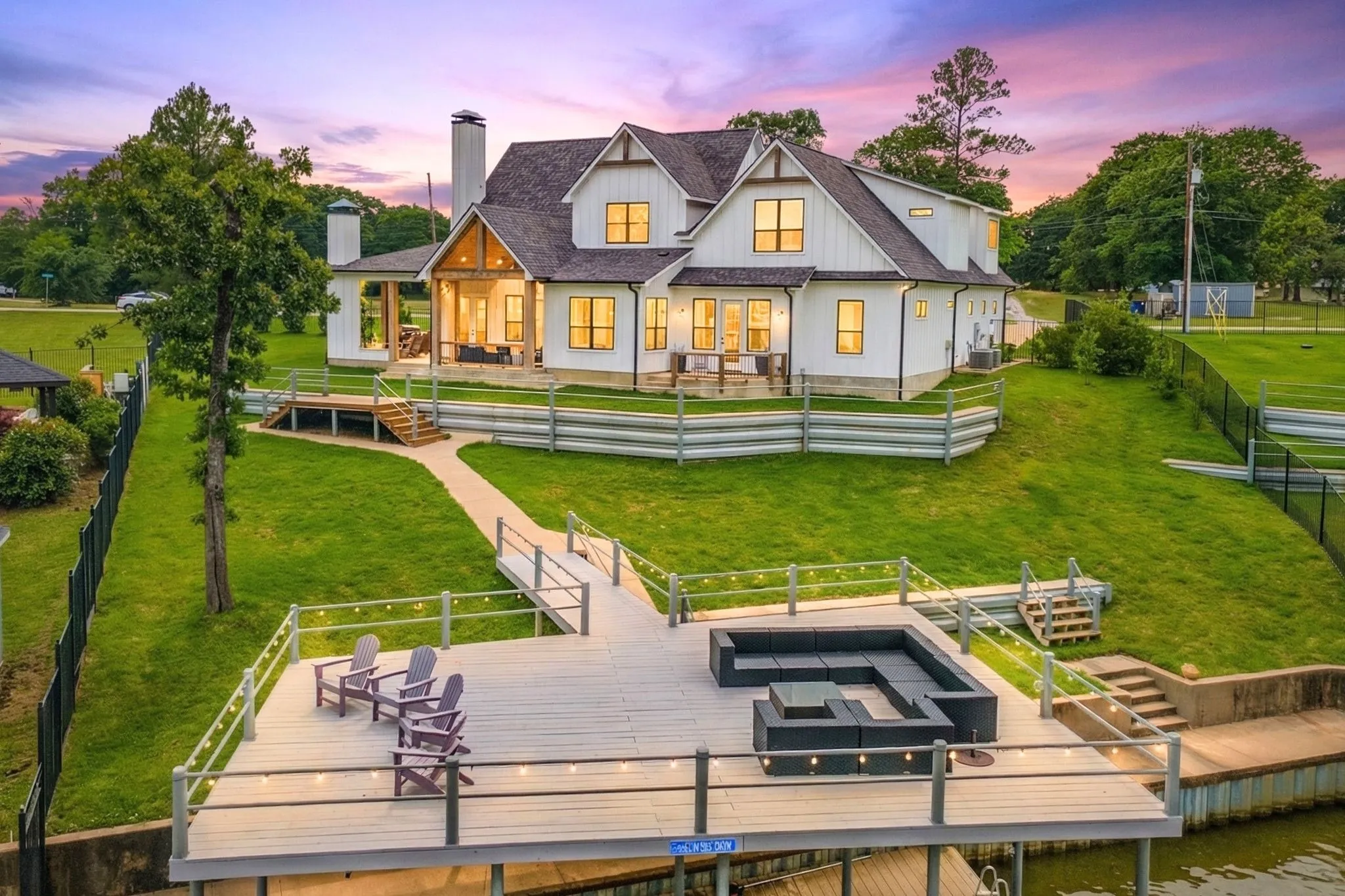 Back of property at dusk featuring a fenced backyard and a chimney
