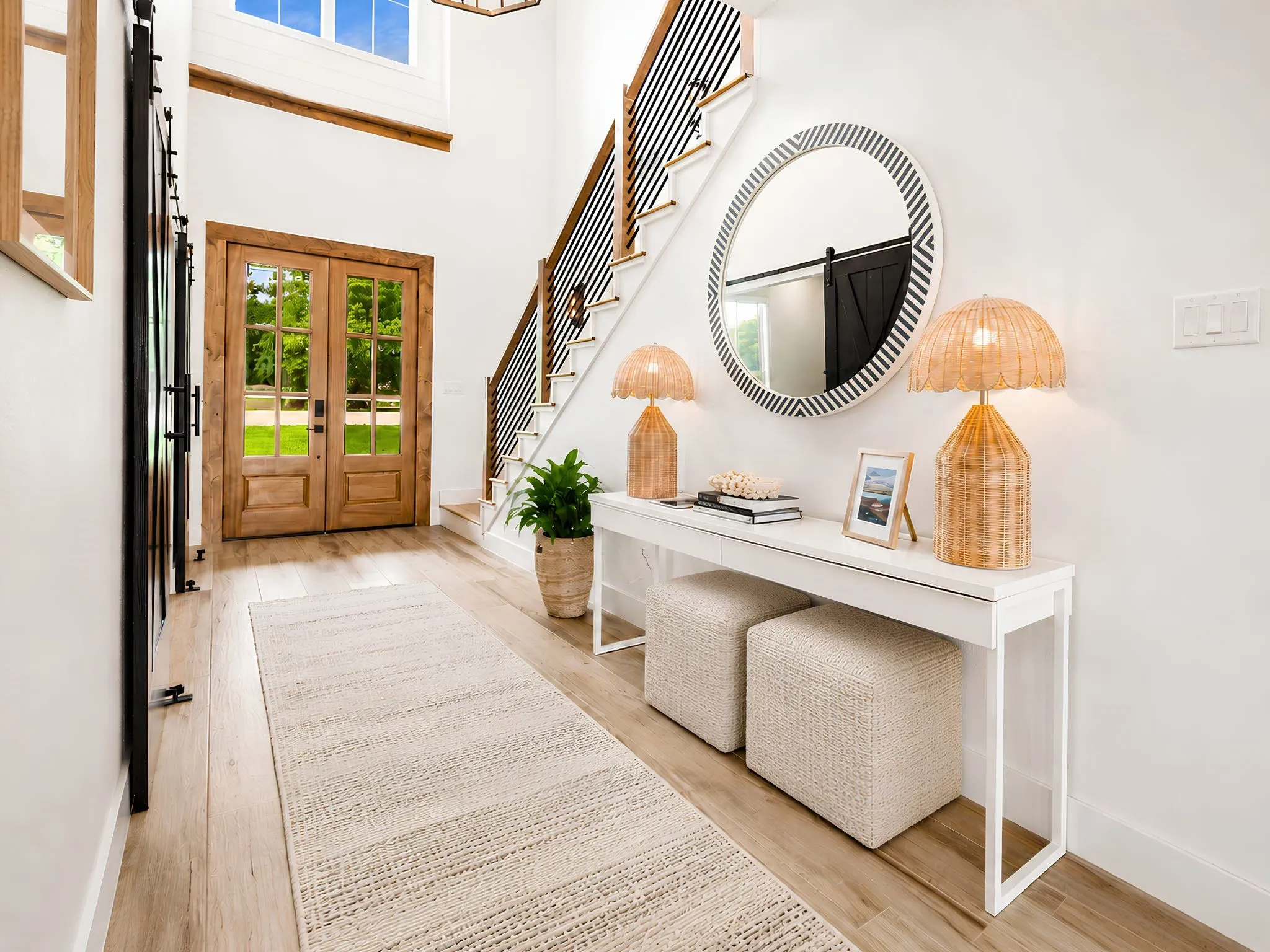 Bright entryway featuring light wood-finish flooring and a staircase with dark metal balusters