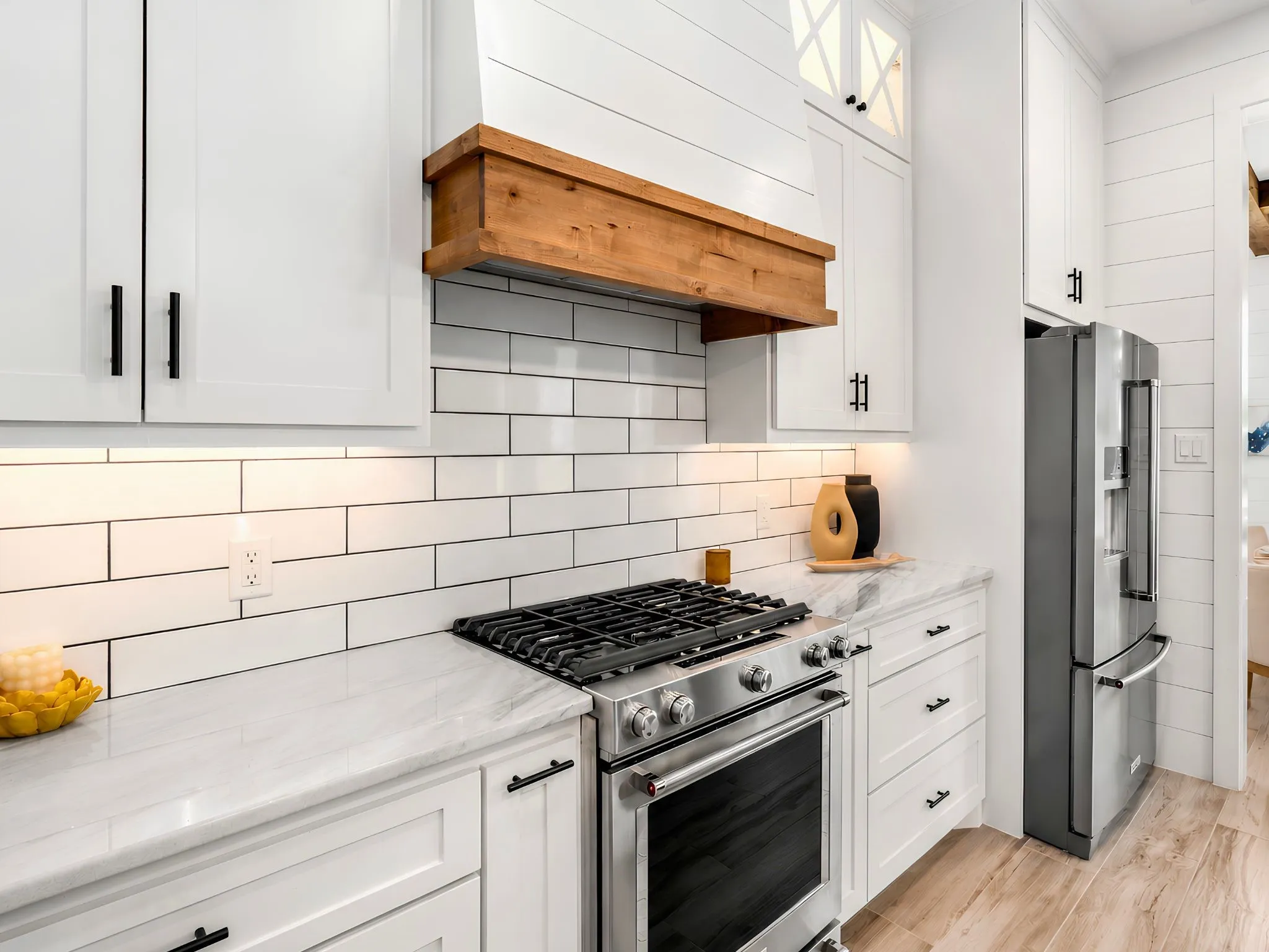 Modern kitchen featuring white shaker cabinetry, white subway tile backsplash, and light-toned countertops