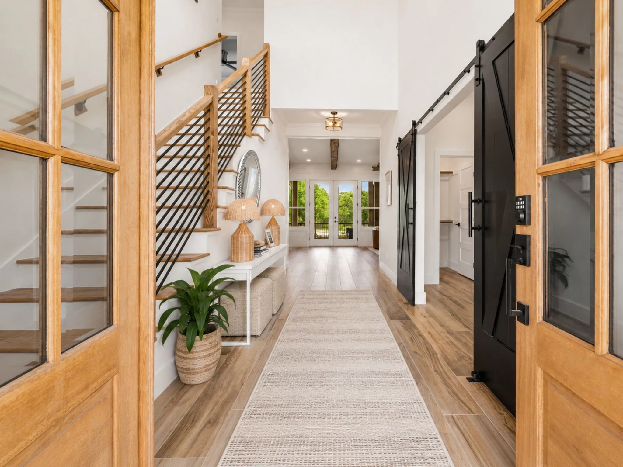 Entryway featuring a grand staircase with wood treads and modern black metal​​‌​​​​‌​​‌‌​‌‌​​​‌‌​‌​‌​‌​​​‌​​ balusters