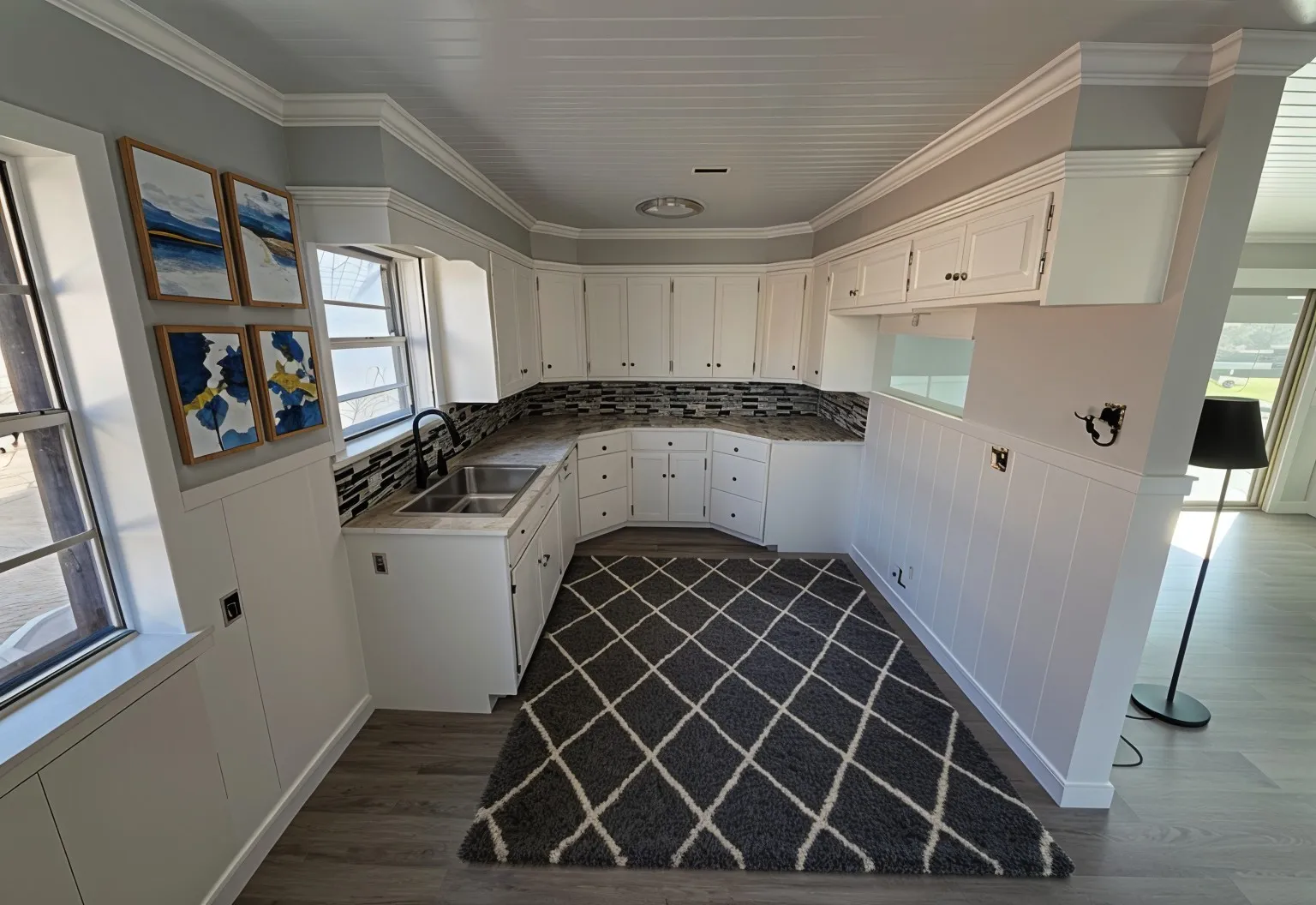 Kitchen with plenty of natural light, crown molding, decorative backsplash, white cabinetry, and dark wood-style floors