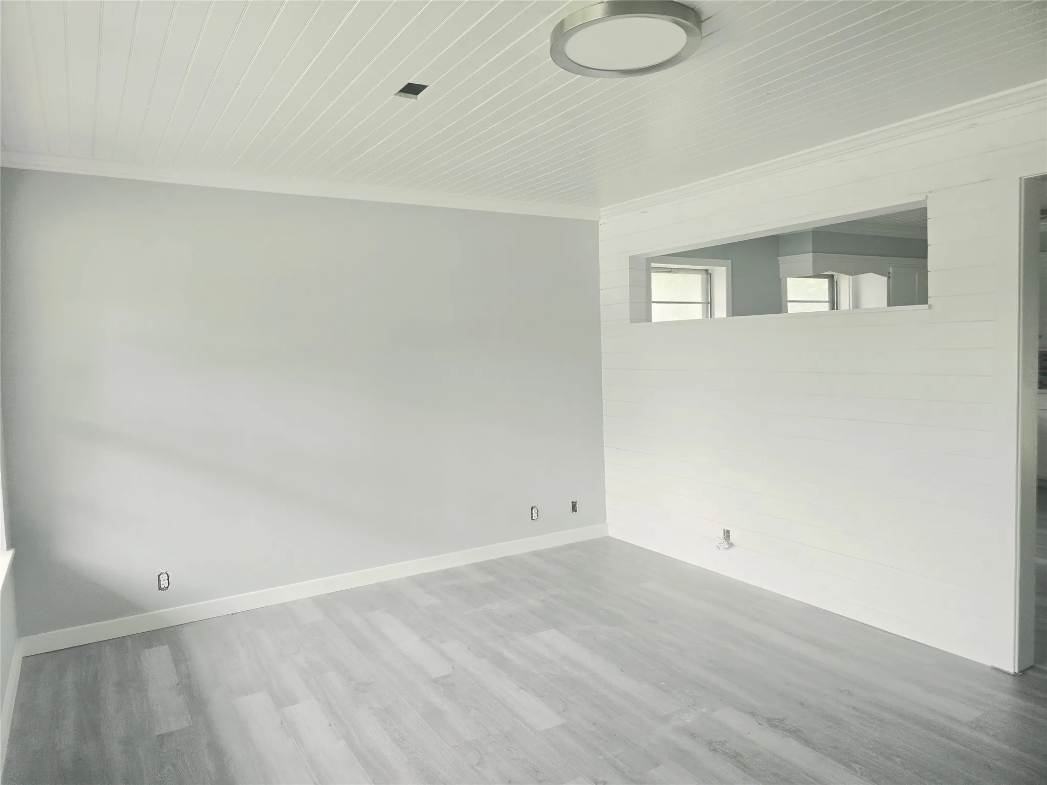 Room featuring wood-finish flooring, light gray wall paint, and white trim updated. 1st Living Room