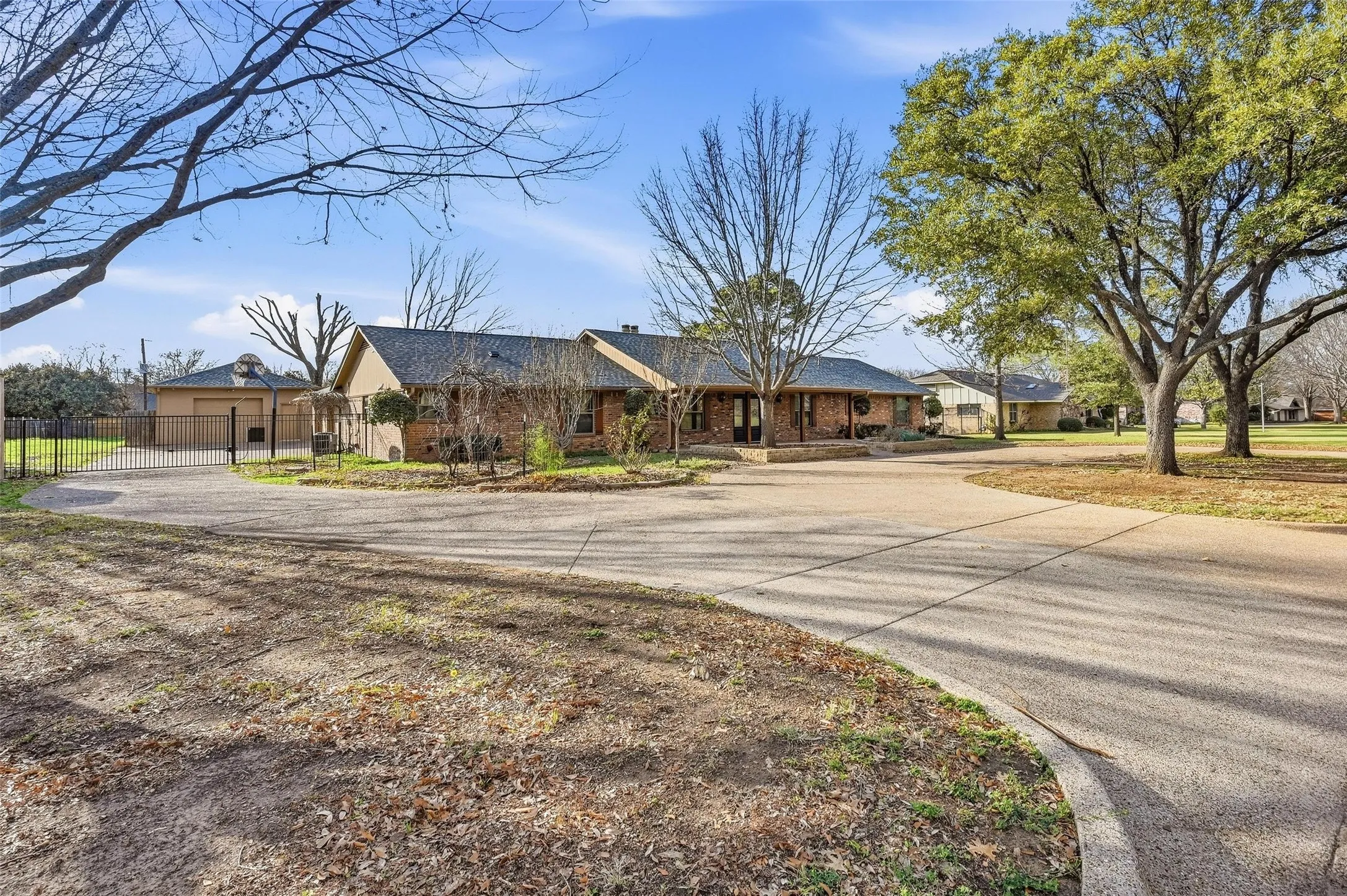 Ranch-style home with brick siding and curved driveway