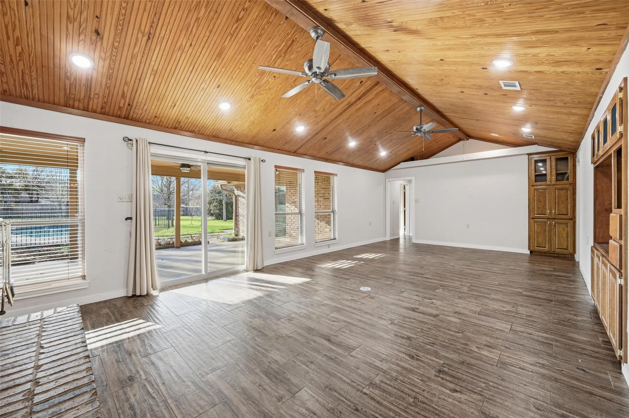 Unfurnished living room featuring dark wood-style floors, a wood ceiling with exposed beams, a ceiling fan, and recessed lighting