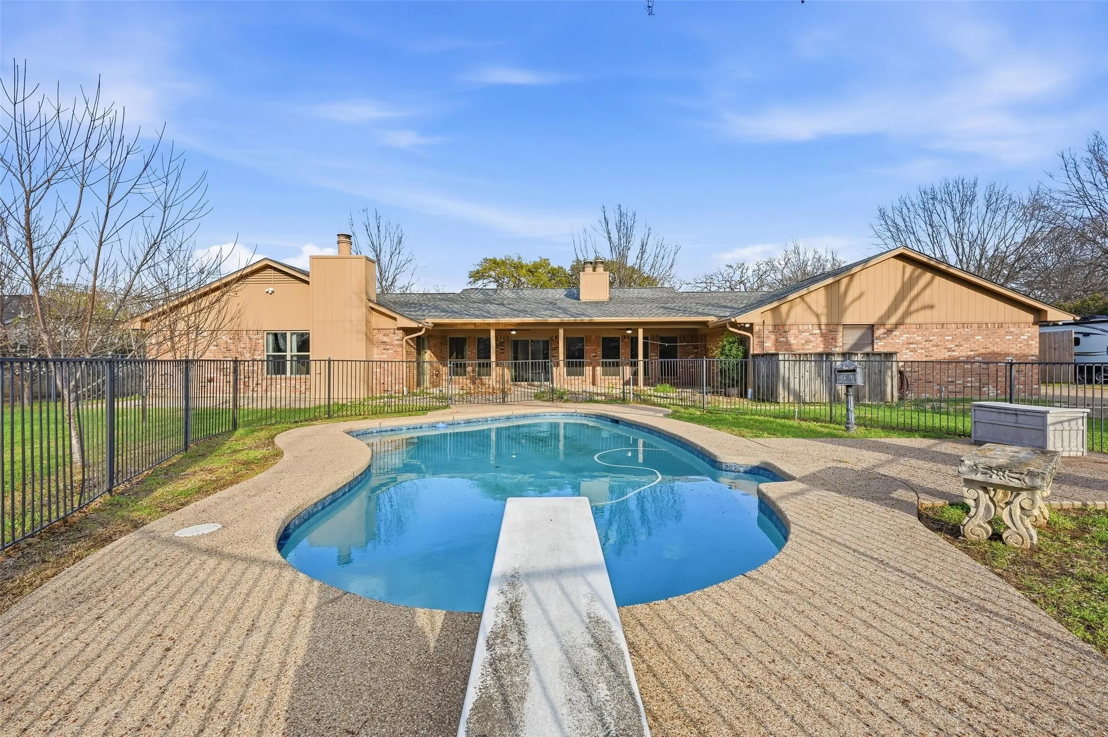 View of pool featuring patio surround and a diving board