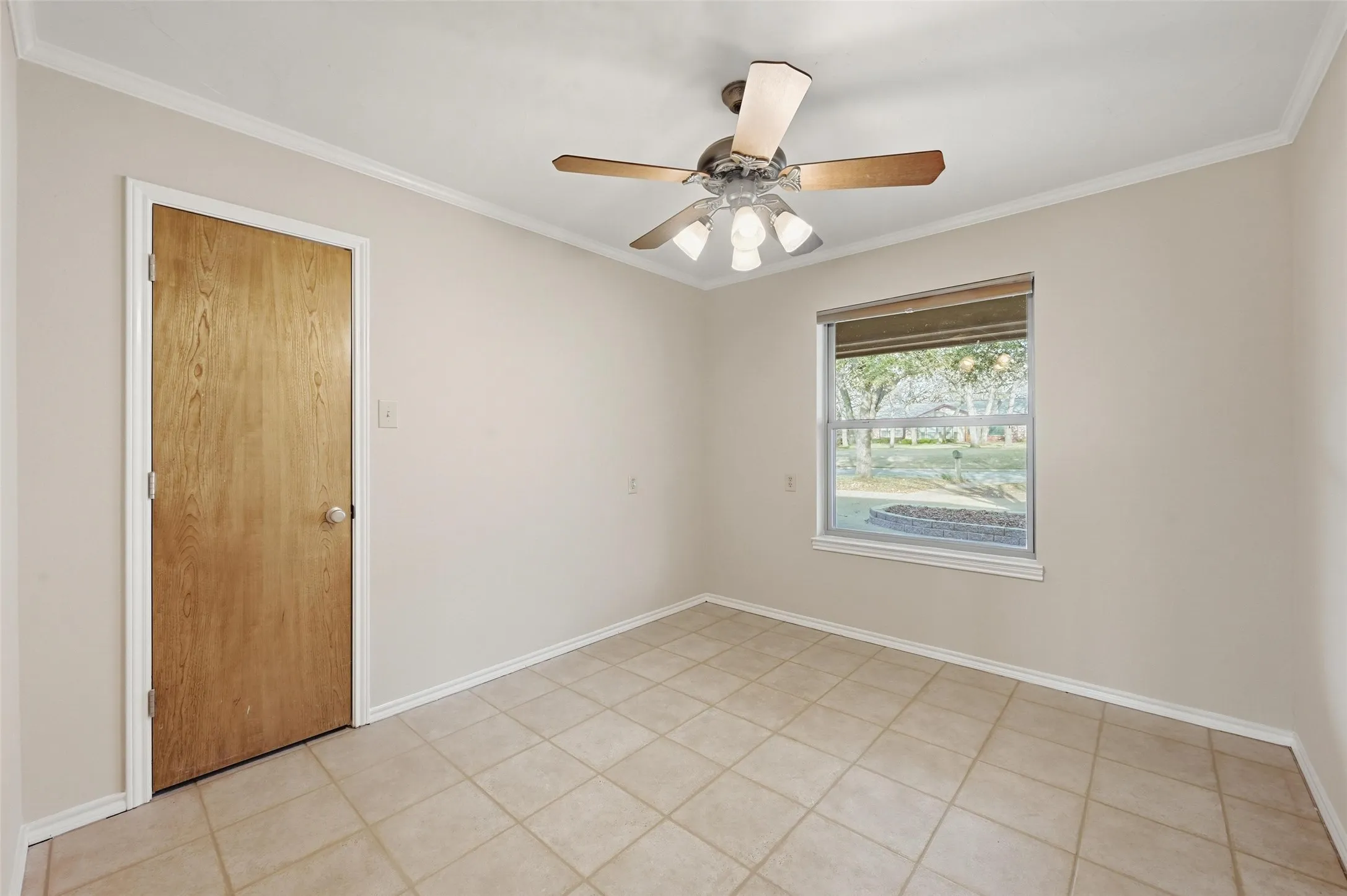 Unfurnished room with ornamental molding, a ceiling fan, and light tile patterned flooring