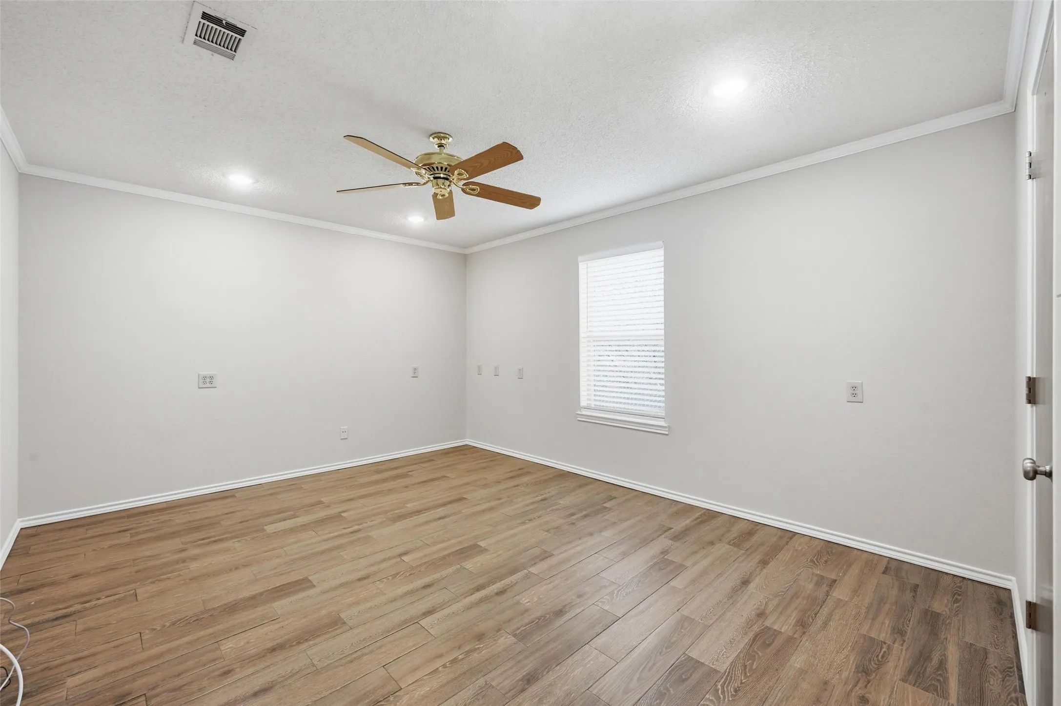 Unfurnished room with a ceiling fan, ornamental molding, wood finished floors, a textured ceiling, and recessed lighting