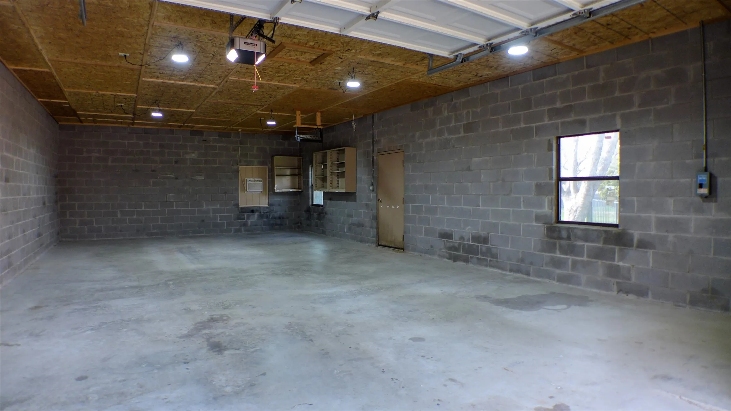 Workshop with concrete block wall and a garage door opener