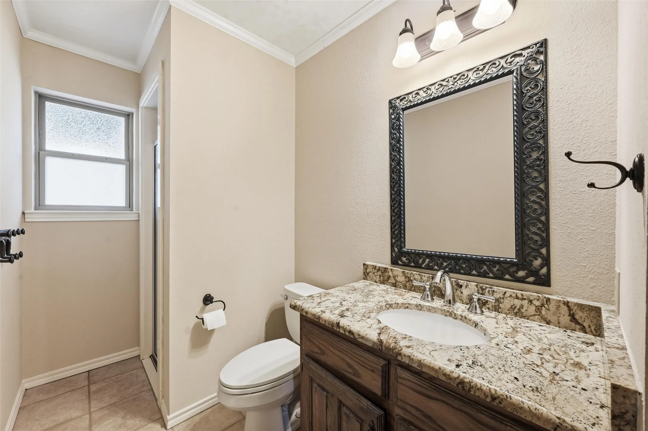 Full bath with vanity, a shower stall, light tile patterned floors, and ornamental molding