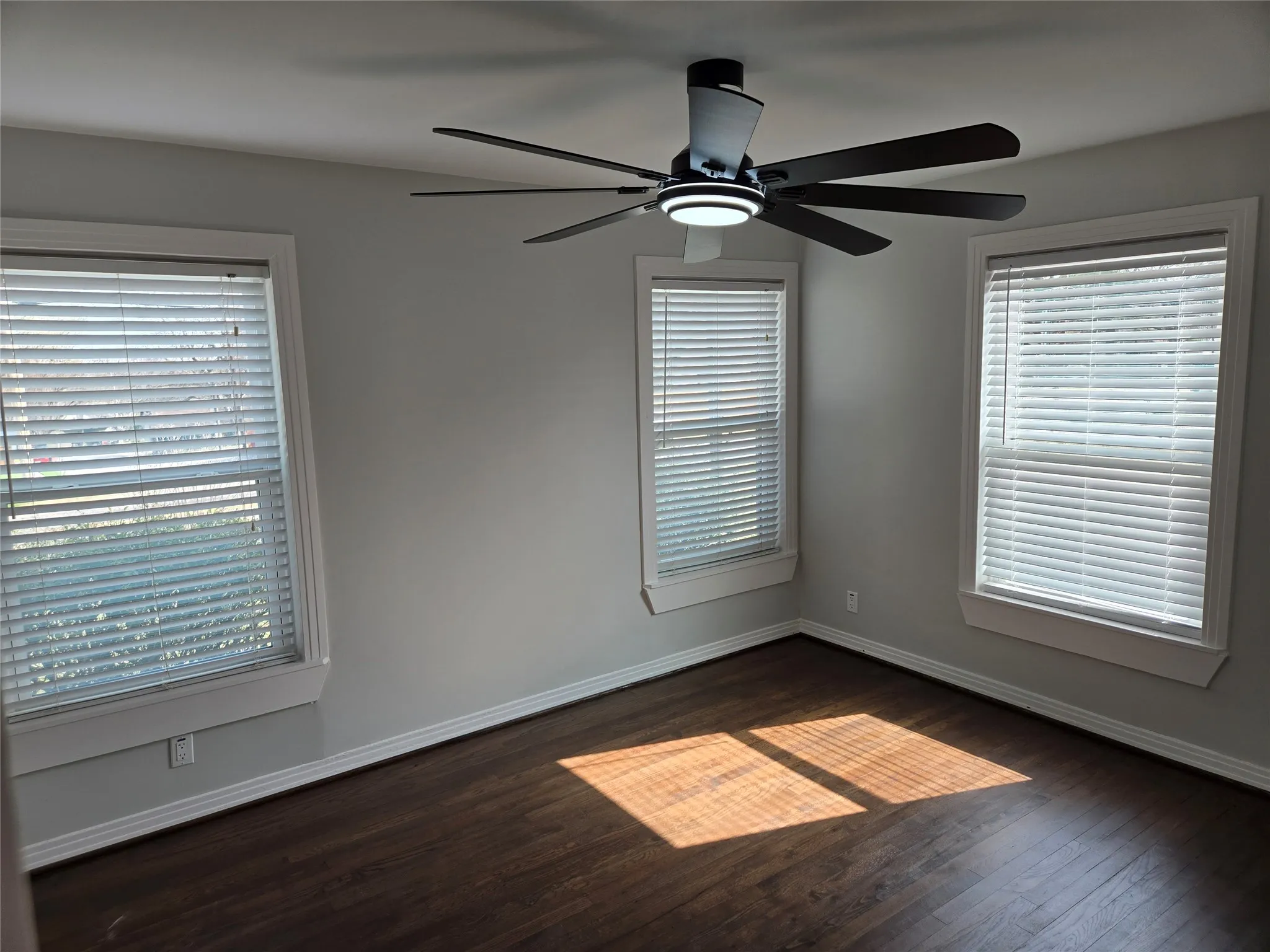 Spare room featuring ceiling fan and dark wood-style floors