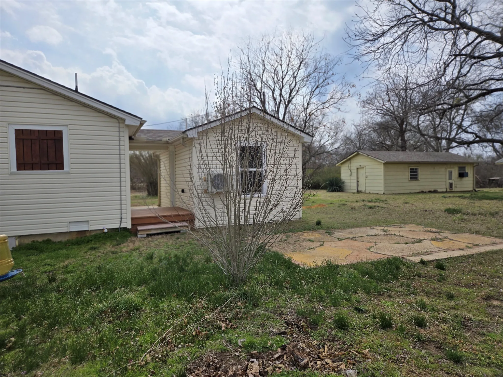 Rear view of house with a deck, a yard, and an outdoor structure