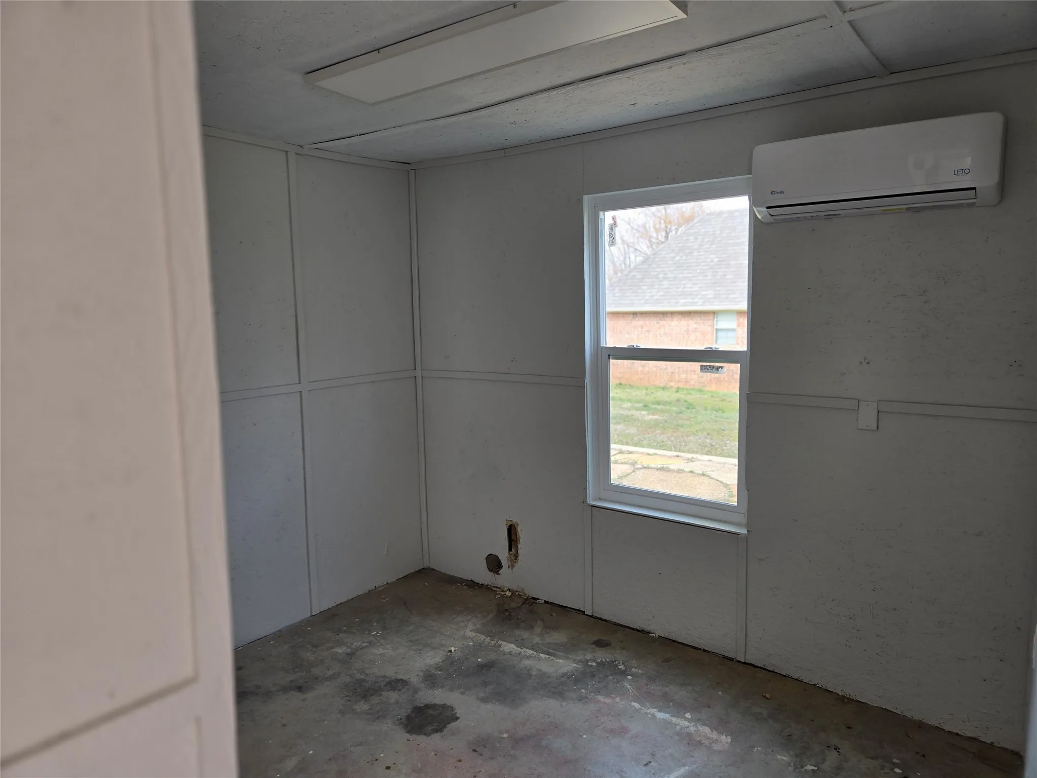 Spare room featuring a mini split for heating / cooling and concrete flooring