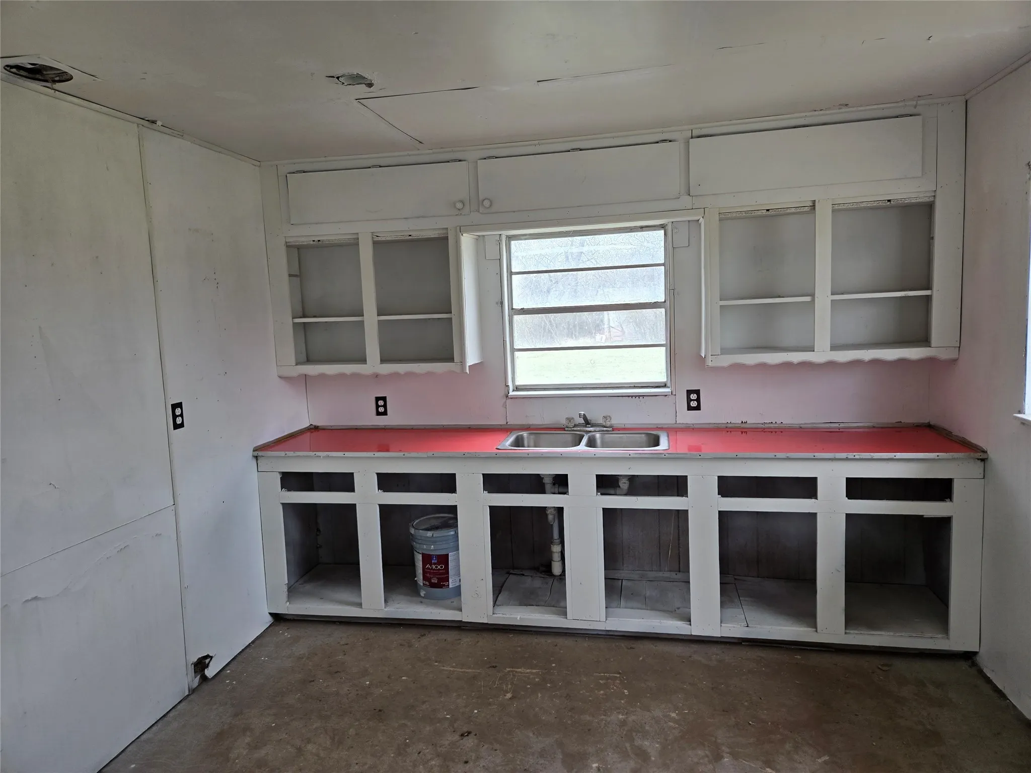 Kitchen featuring concrete flooring and light countertops