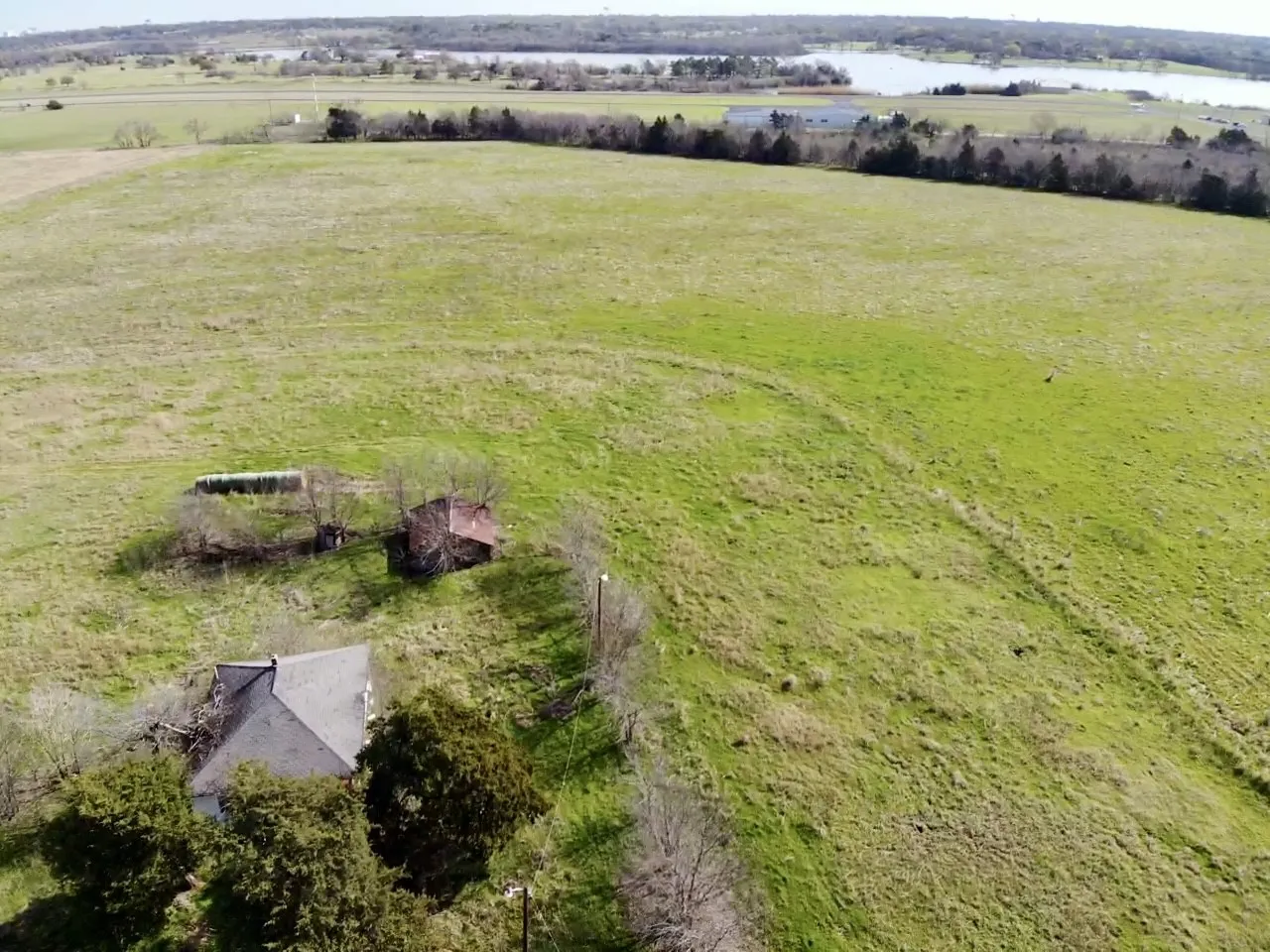 Aerial view over pasture behind 2 acre house
