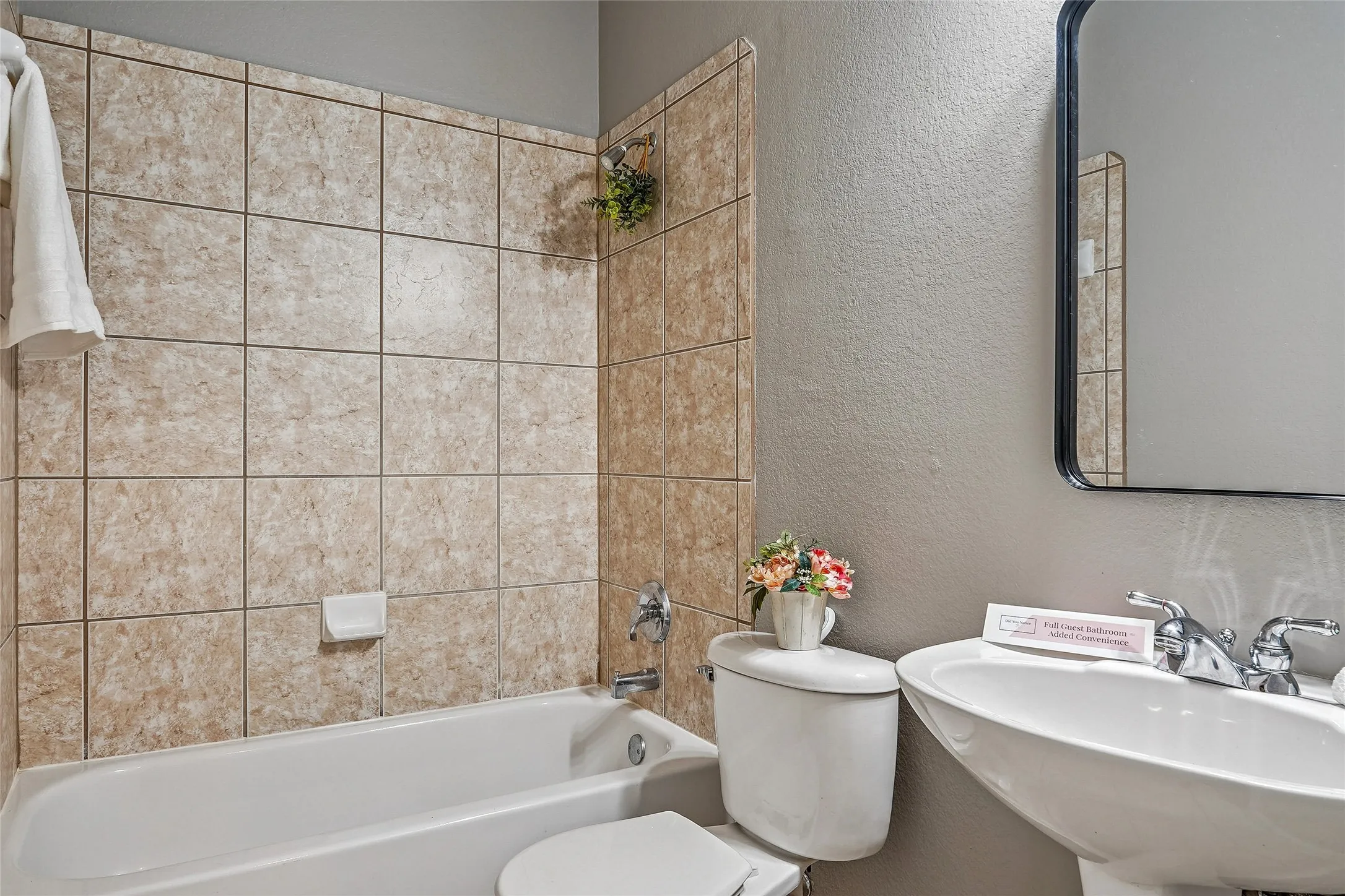 Full bath with a textured wall and  shower combination