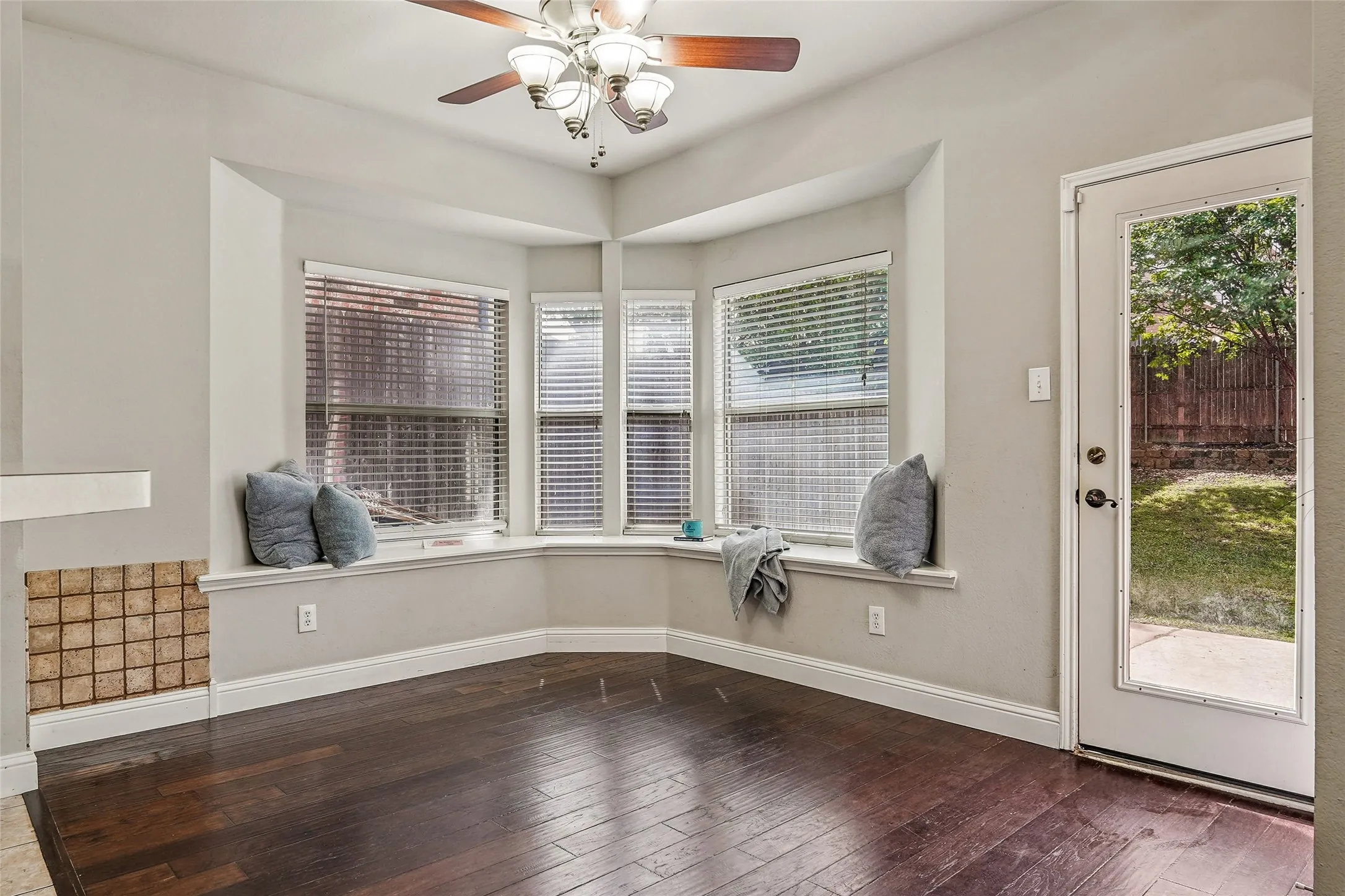 Unfurnished dining area featuring a ceiling fan and dark wood-style floors