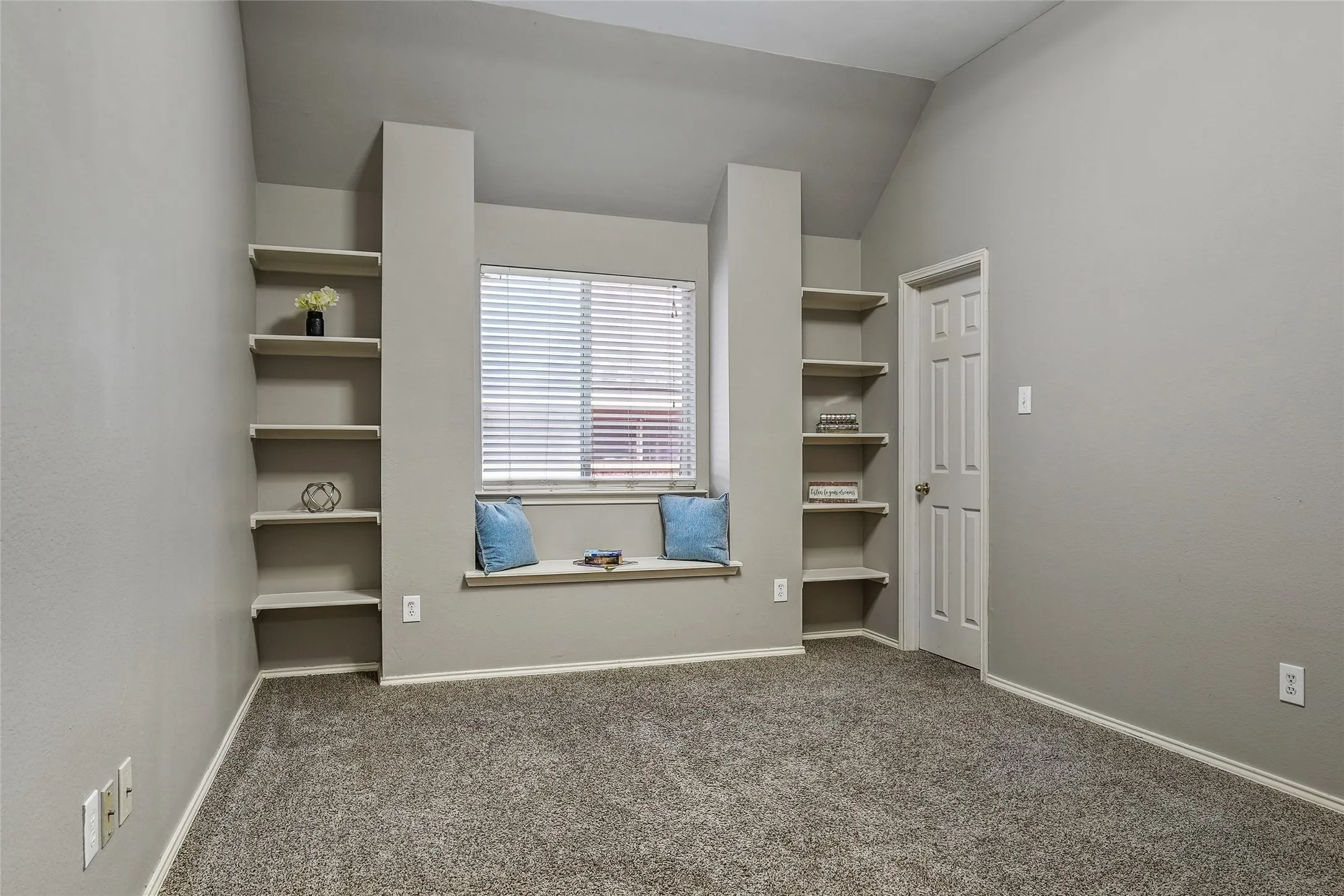 Unfurnished bedroom featuring dark carpet and lofted ceiling