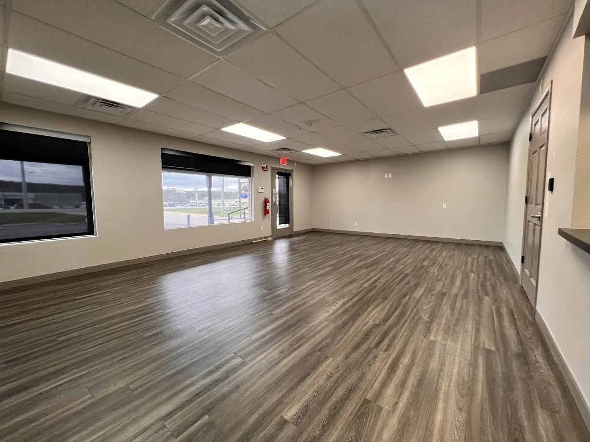 Empty room featuring a paneled ceiling and dark wood-style floors