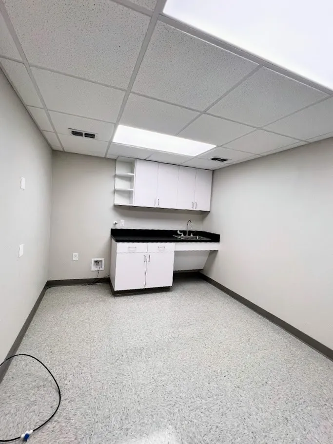 Unfurnished office with a paneled ceiling and dark speckled floor