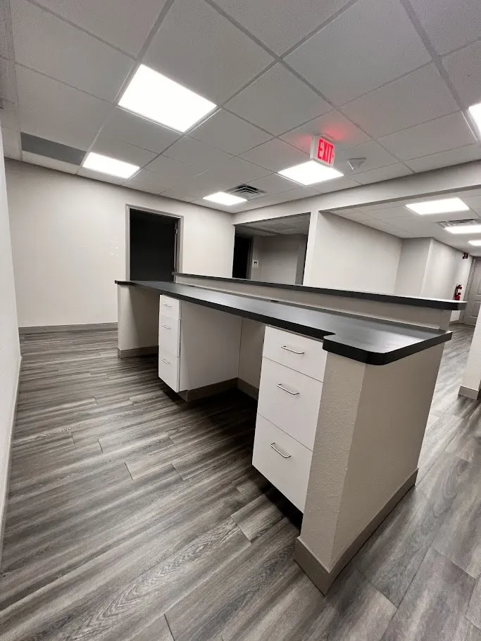 Unfurnished office with a drop ceiling and built in desk