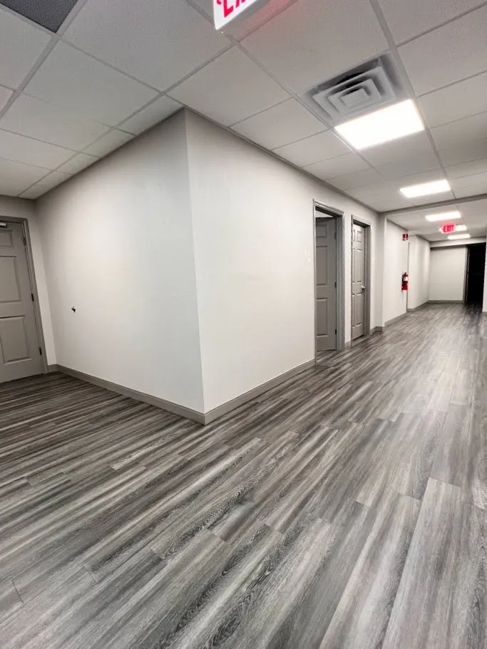 Empty room featuring a drop ceiling and dark wood-style flooring